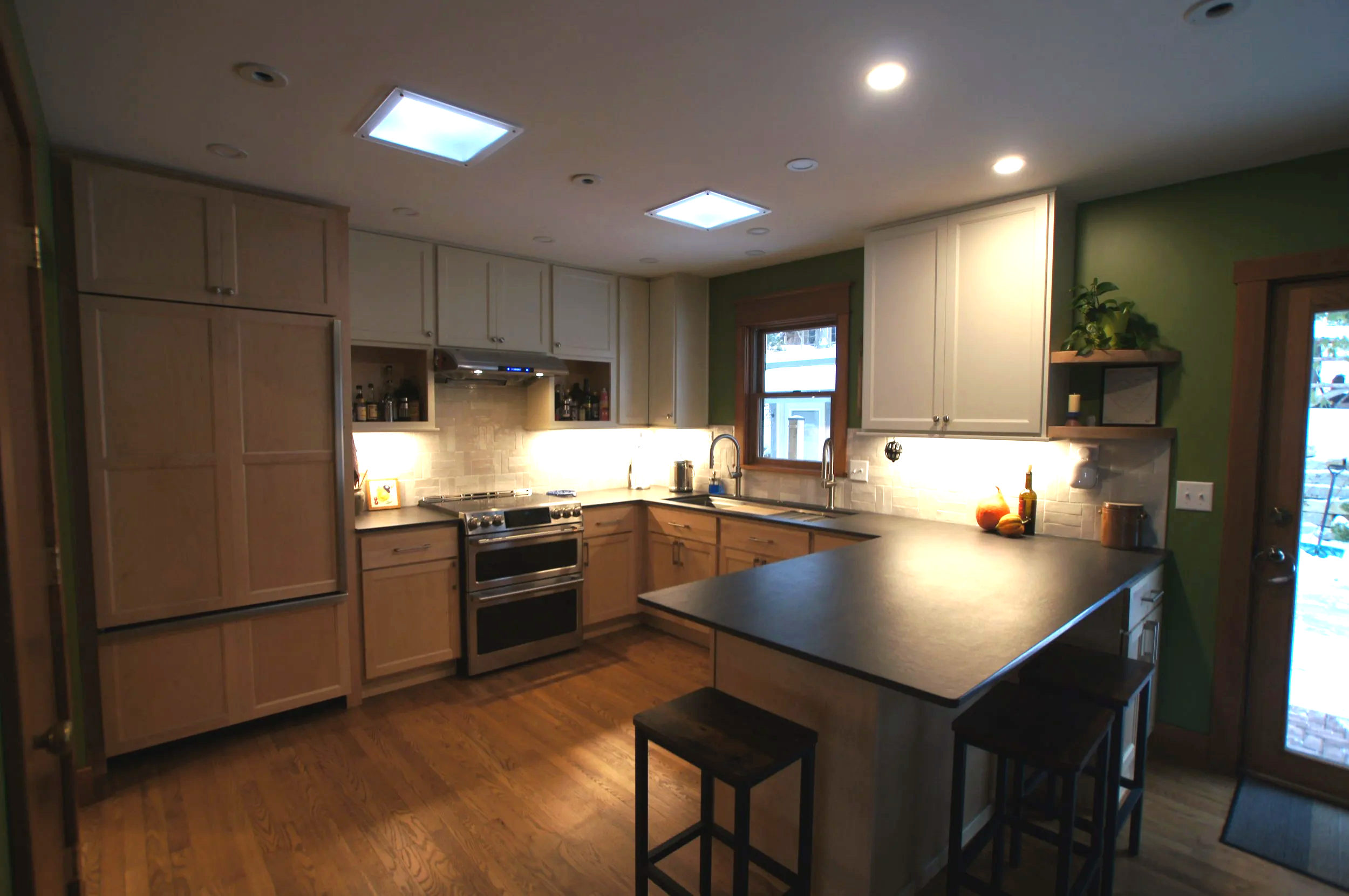 This cozy kitchen uses two toned cabinetry and high contrast countertops to reflect the mid century modern period of the home.