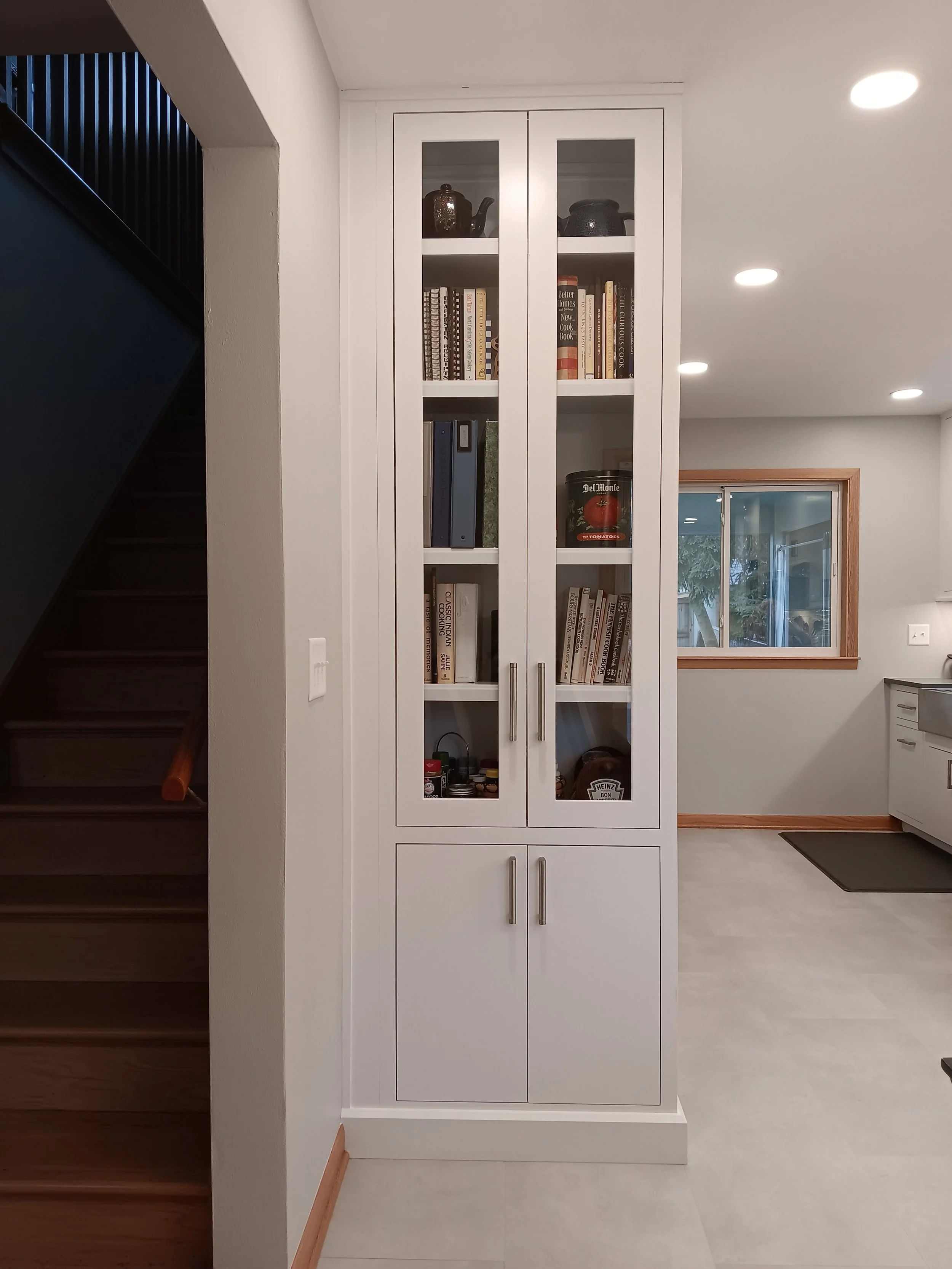 This tall cabinet allows cook books to be on display and in arm's reach of the kitchen. 