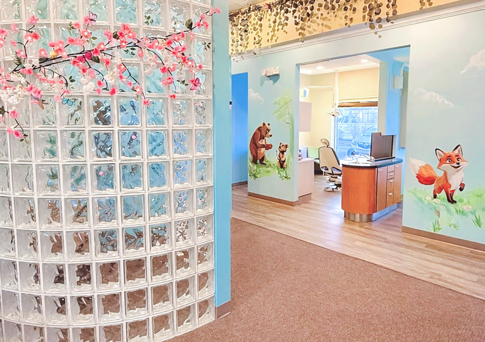 exam room with fox and bear murals in the hallway