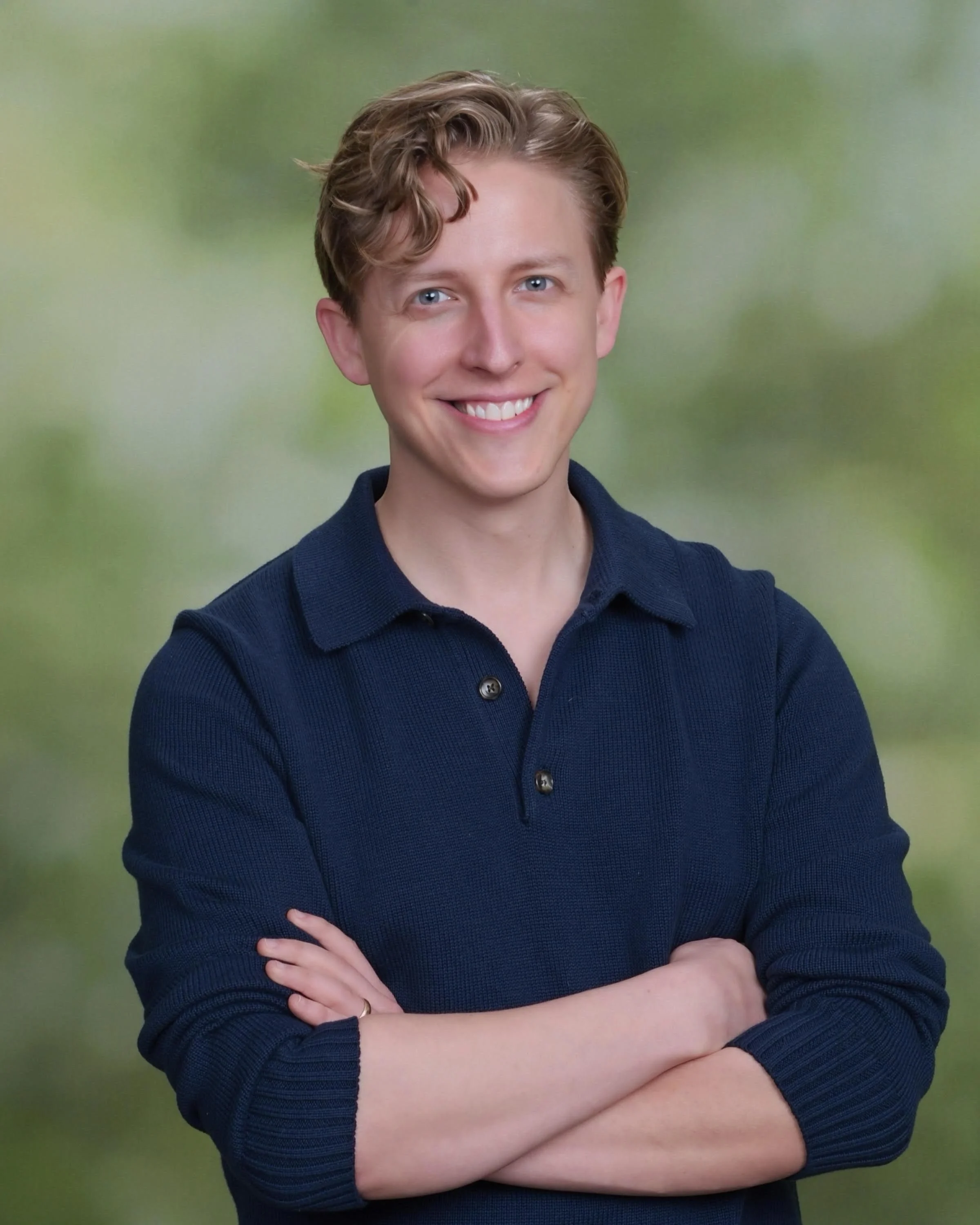 Pediatric dentist Dr. Matt Freihofer smiling with arms crossed wearing navy blue shirt