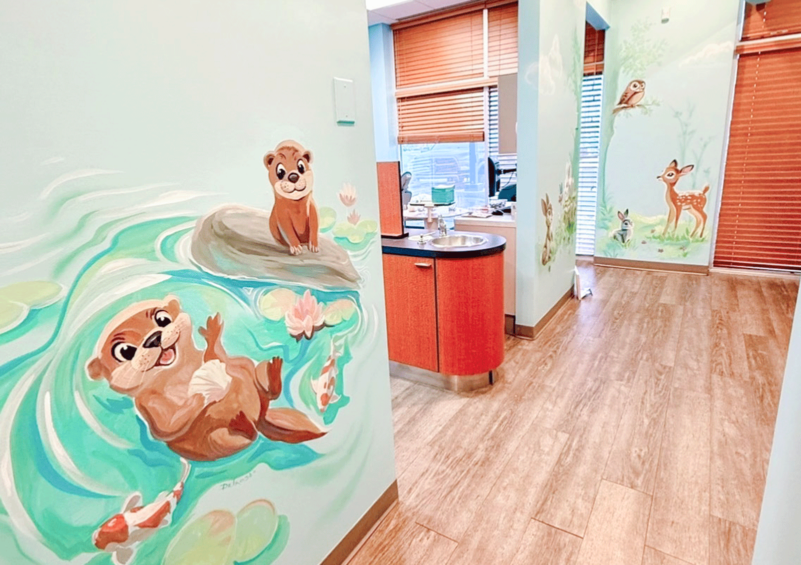 otter mural on wall in hallway with exam room in background