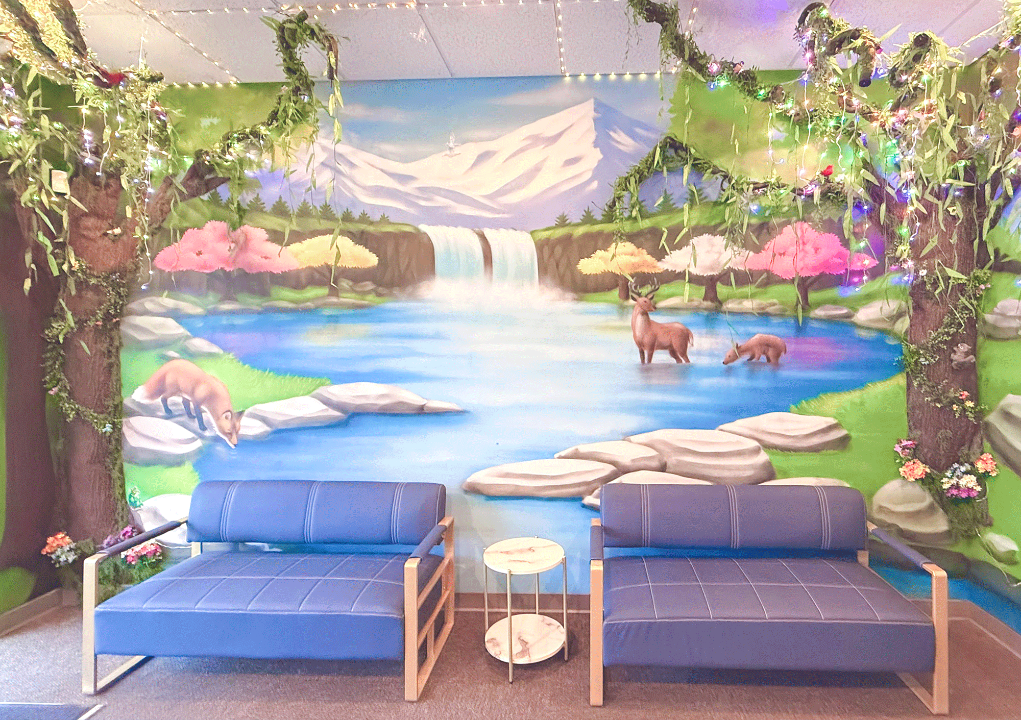 waiting area with whimsical mural of pond and waterfall with deer
