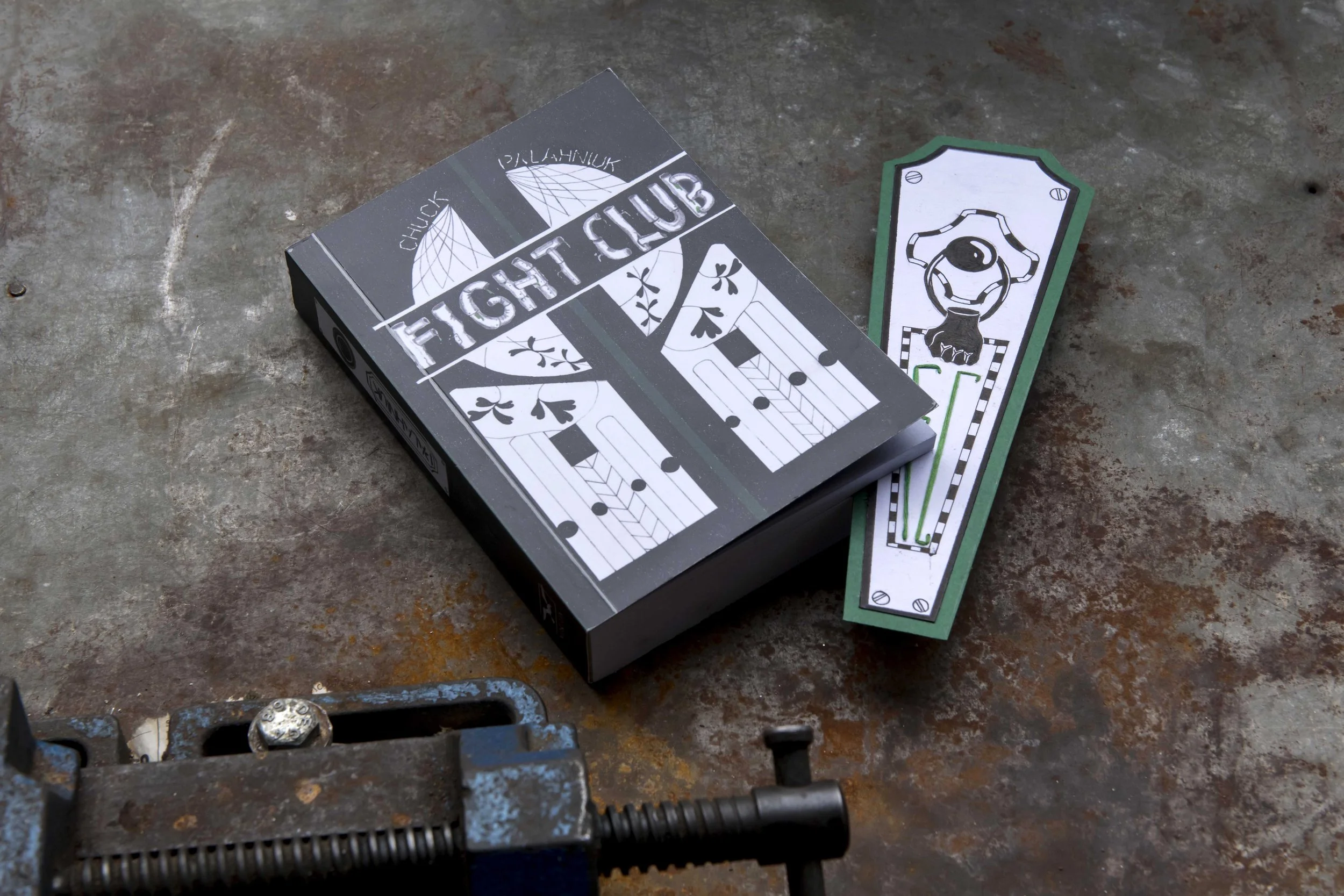 A box of Fight Club playing cards and a green and white card with a fist illustration on a rusted metal surface. LEA SABAN, DOĞU & ERİNÇ PORTFOLYO HAZIRLIK ATÖLYESİ VE EĞİTİM DANIŞMANLIĞI