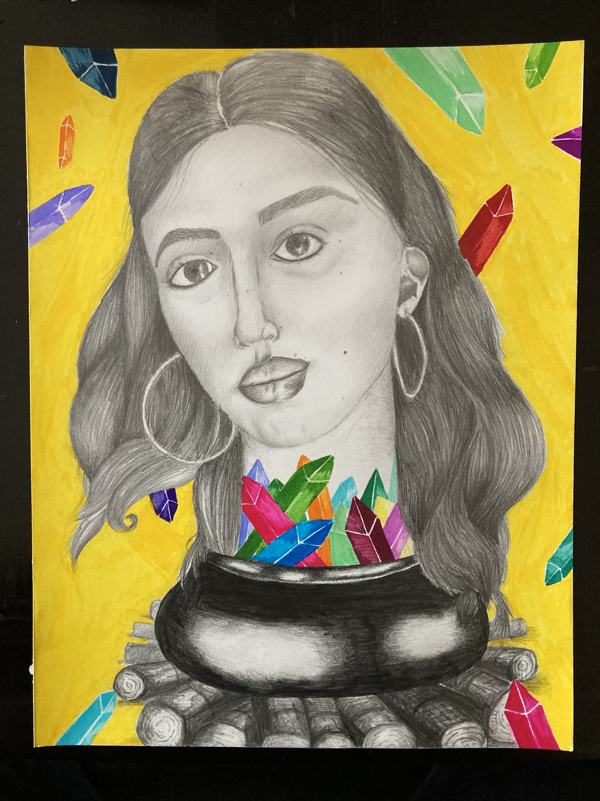 A drawing of a young woman with long hair, wearing hoop earrings, with a serious expression on her face. The drawing is in black and white, with a colorful background and foreground featuring bright, multicolored crystals surrounding a black cauldron