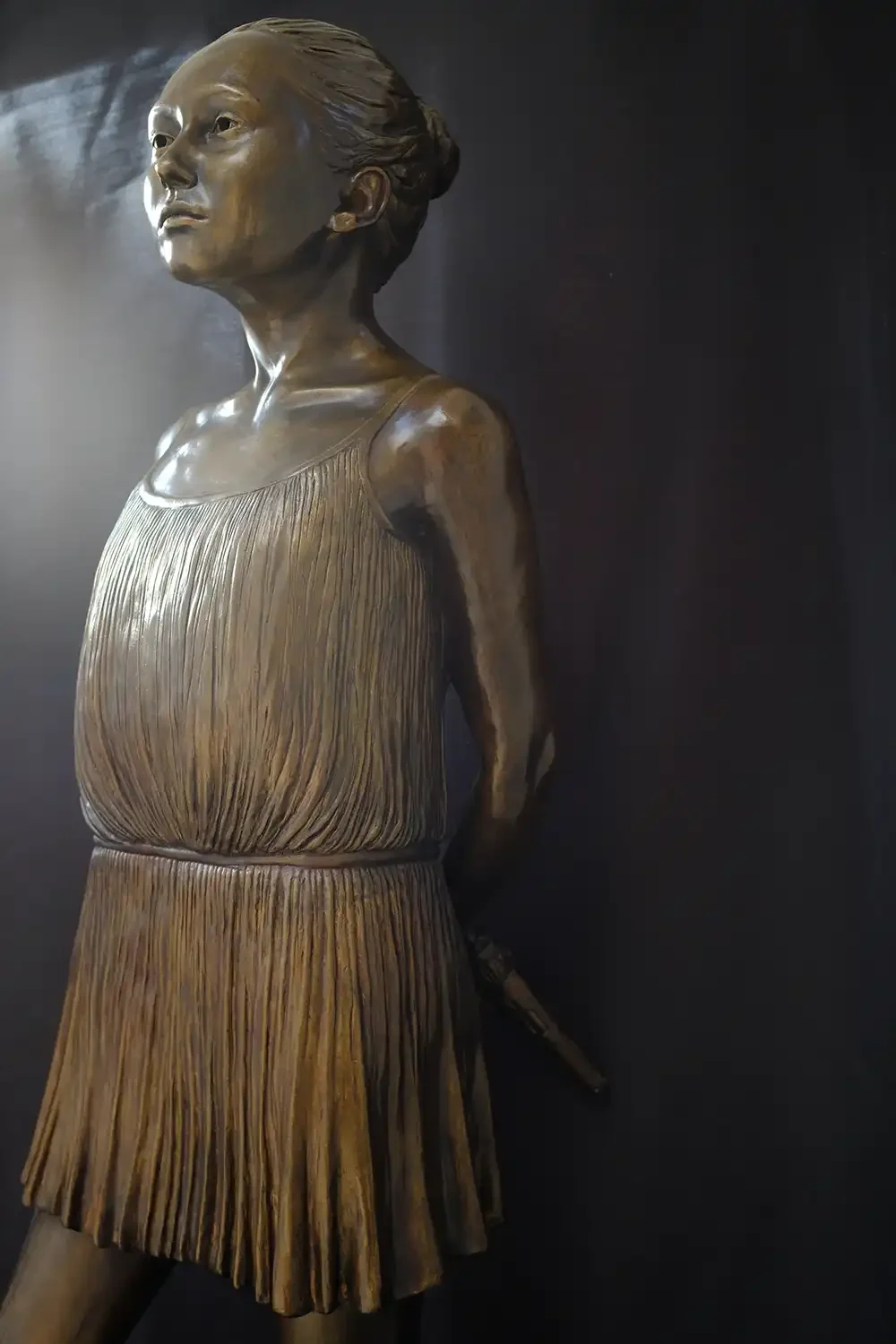 Life size hand sculpted young goddess figure with weapon in patinated bronze