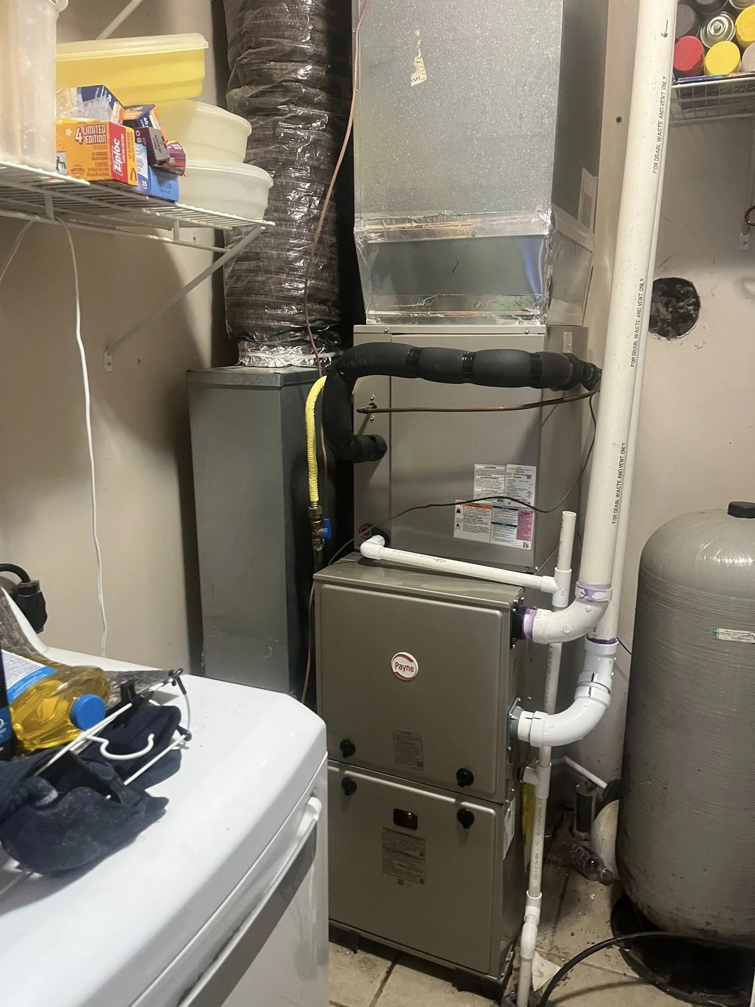 Mechanical room with HVAC system, pipes, ductwork, and a large water tank.