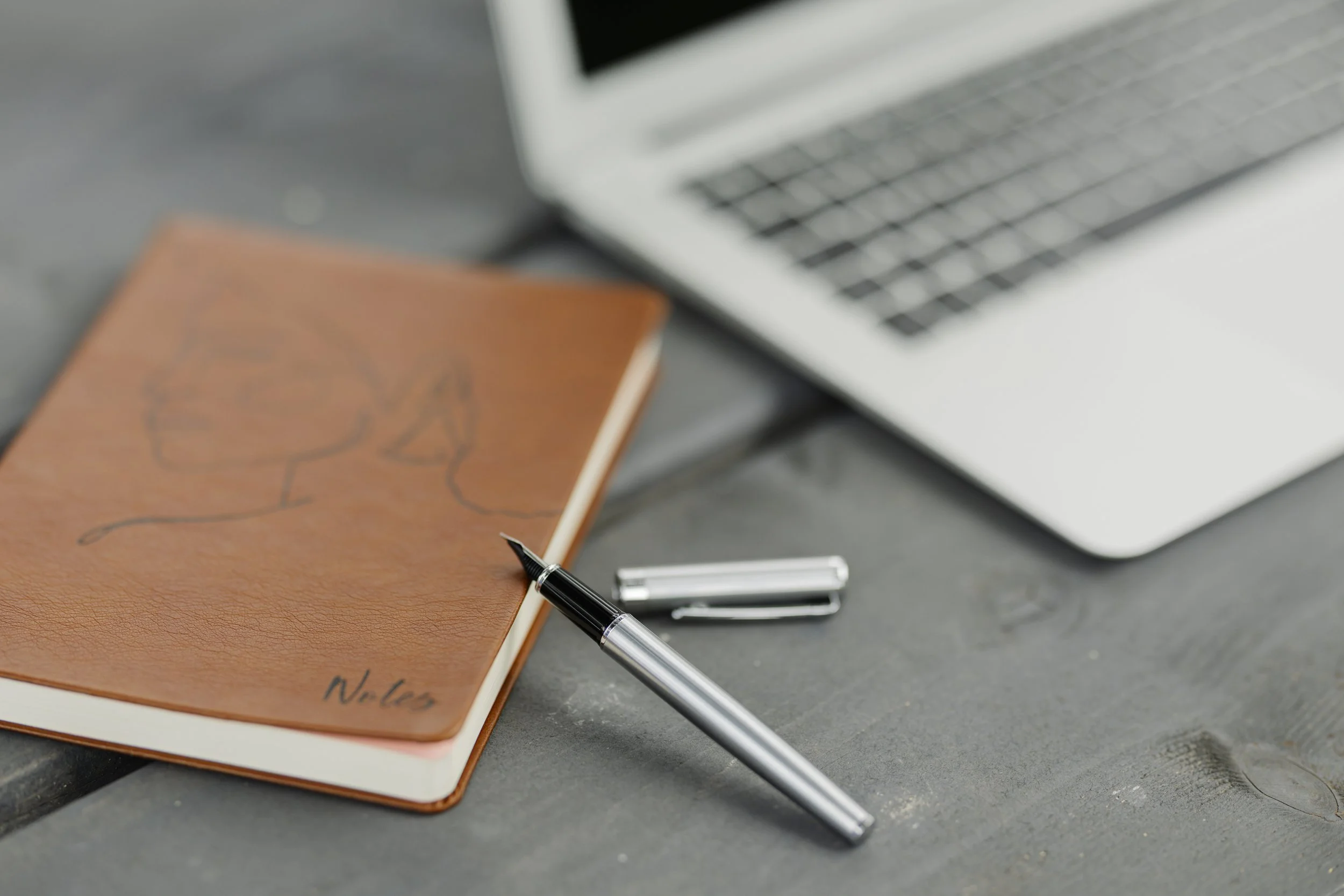 Notebook, pen and laptop representing an introductory therapy consultation.