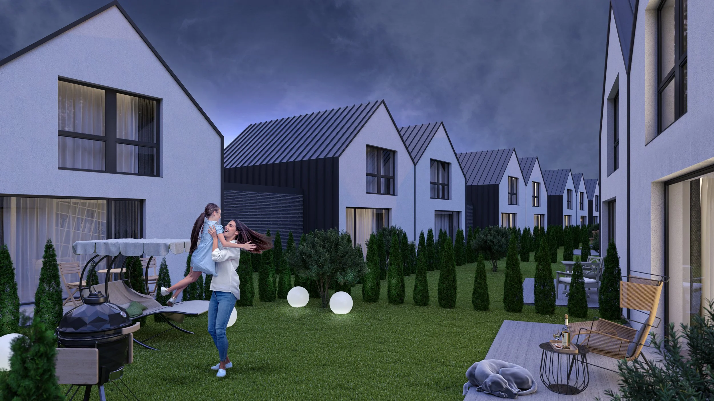 A woman is lifting a girl in a light blue dress in a backyard at dusk, surrounded by modern houses with white and black exteriors, lush green lawn, and outdoor furniture including a swing, chairs, and a table with drinks.