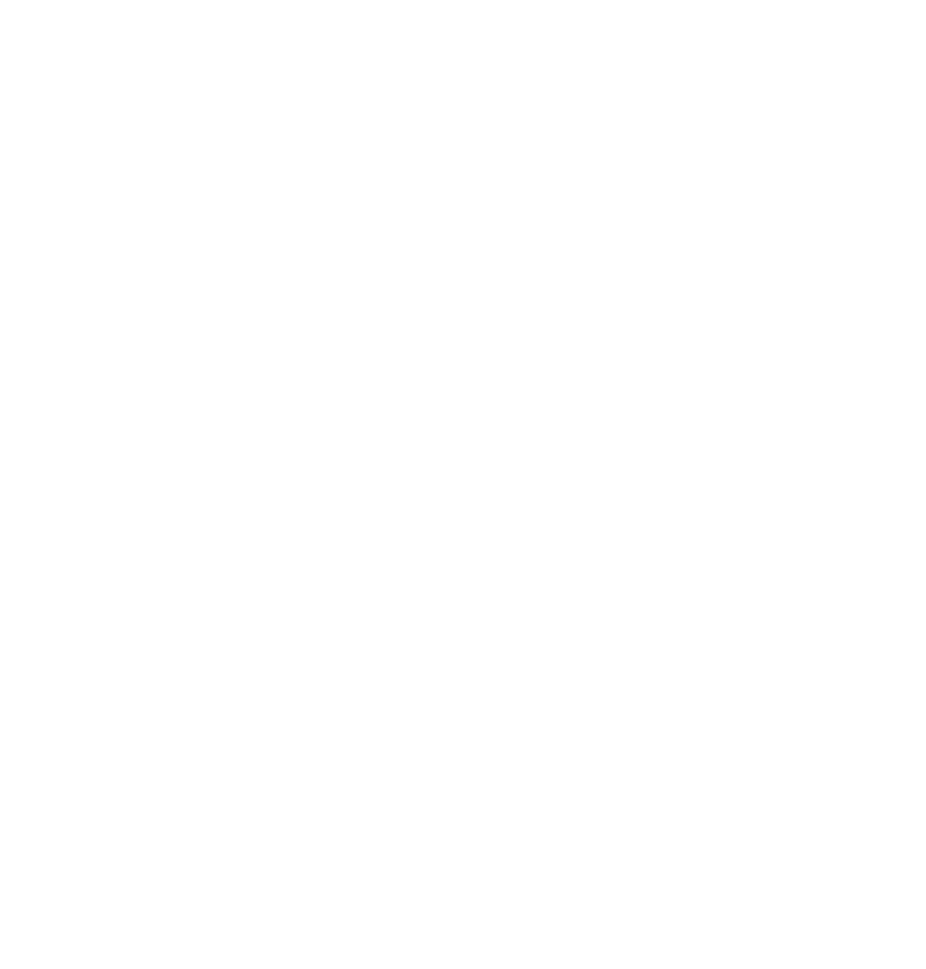 A person sitting at a desk with a laptop, surrounded by books and papers, in an office or study environment.