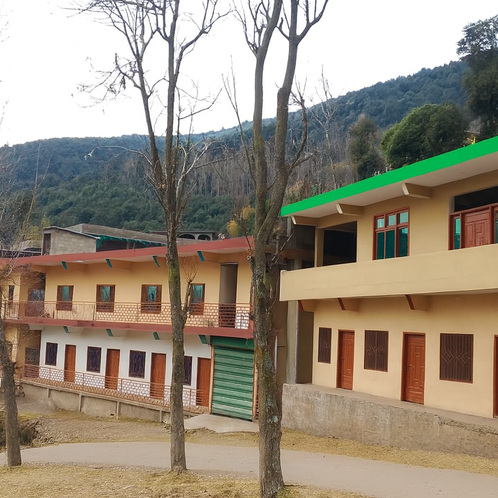 Two leafless trees in front of two buildings with a mountain in the background.