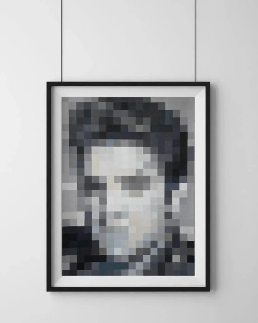 Pixelated black-and-white portrait of a person framed and hanging on a gray wall.