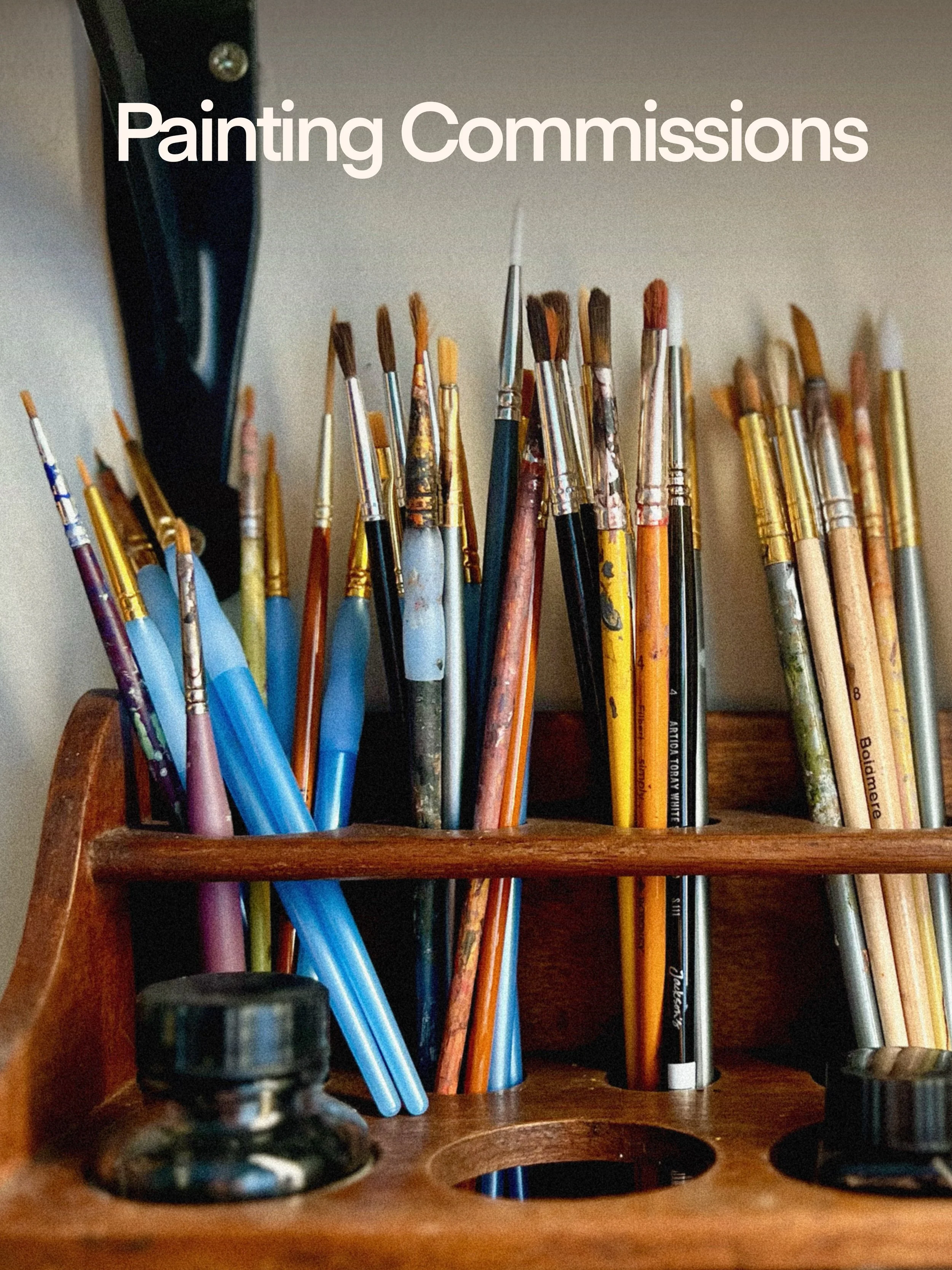 A wooden art supply organizer holding a variety of paintbrushes and colored pencils.