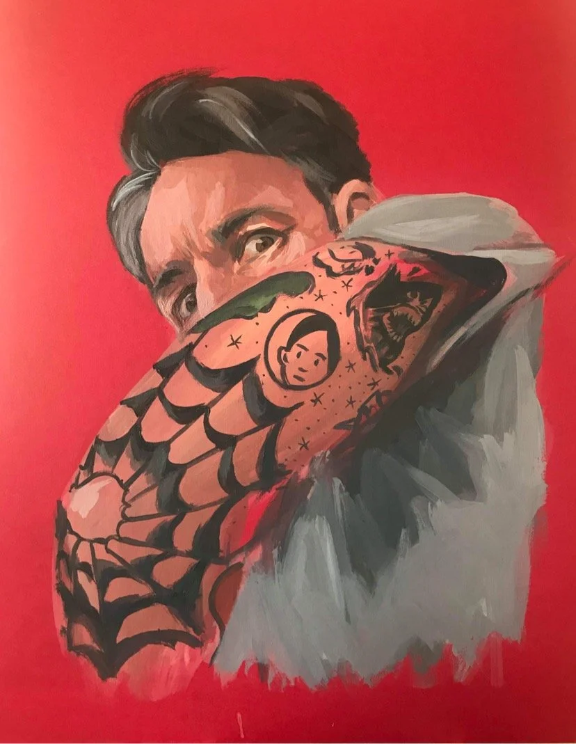 A painting of a man with dark hair and expressive eyes, with his elbow extended towards the camera. His arm is tattooed with various designs, including a woman's face, a tiger, and a spider web. The background is bright red.