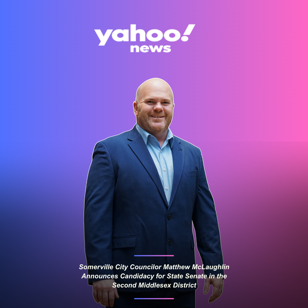 A man in a blue suit and light blue shirt standing in front of a purple-pink gradient background with the Yahoo News logo, with text announcing Matthew McLaughlin's candidacy for State Senate in the Second Middlesex District.