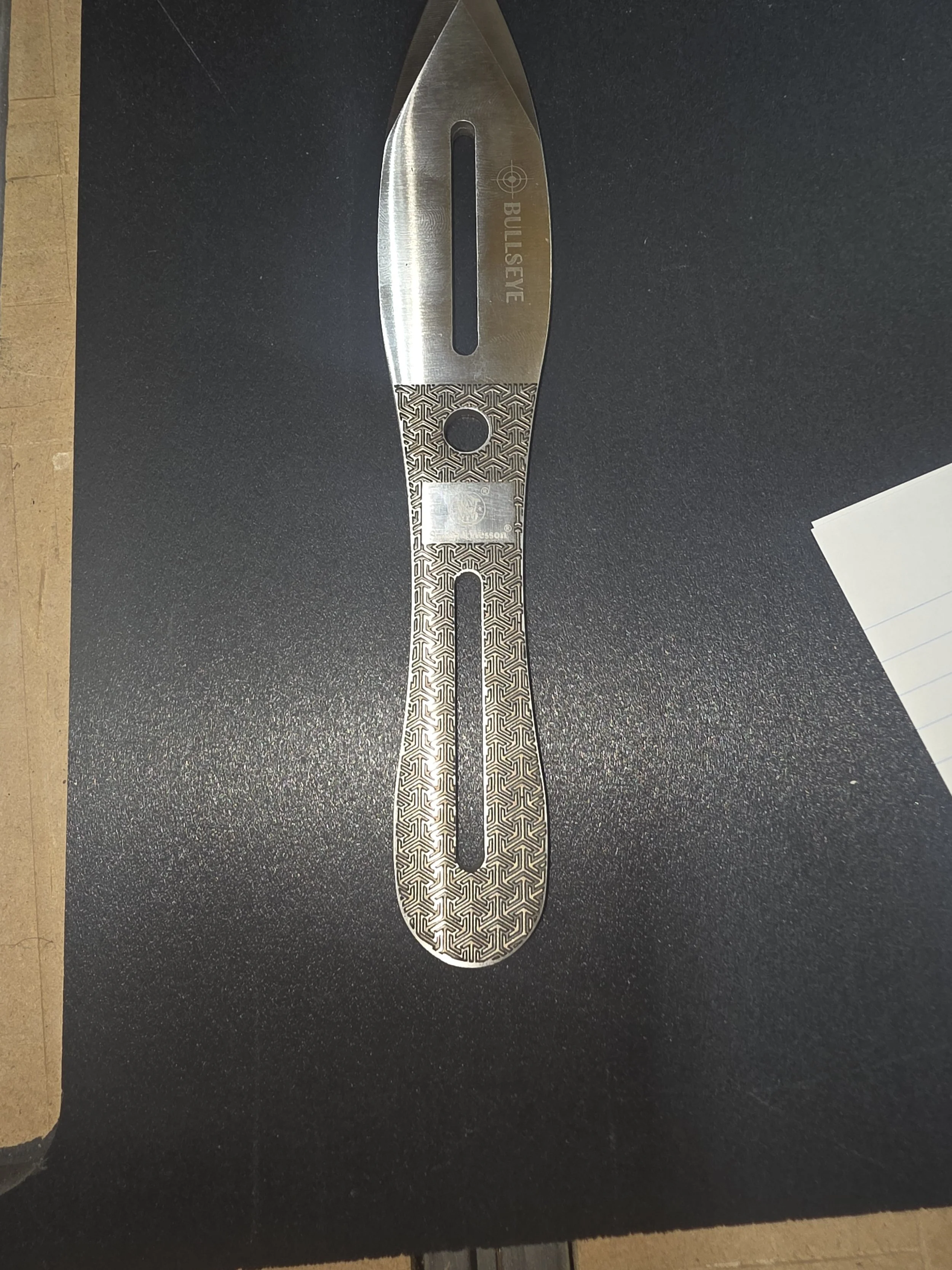 A sleek, metallic heat cutting tool with a patterned handle, labeled 'BULLSEYE,' and a central hole for hanging.