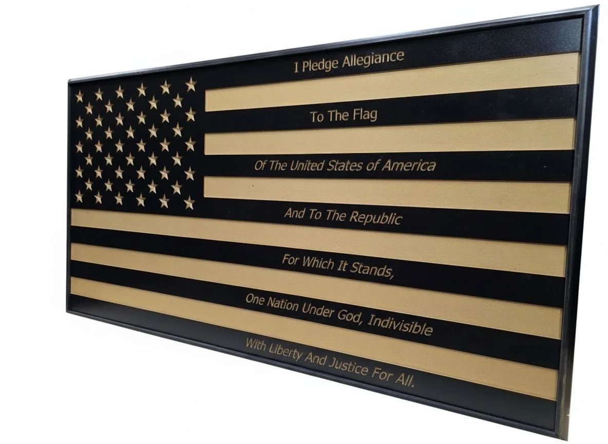 A framed black and gold American flag with the Pledge of Allegiance written across the stripes.
