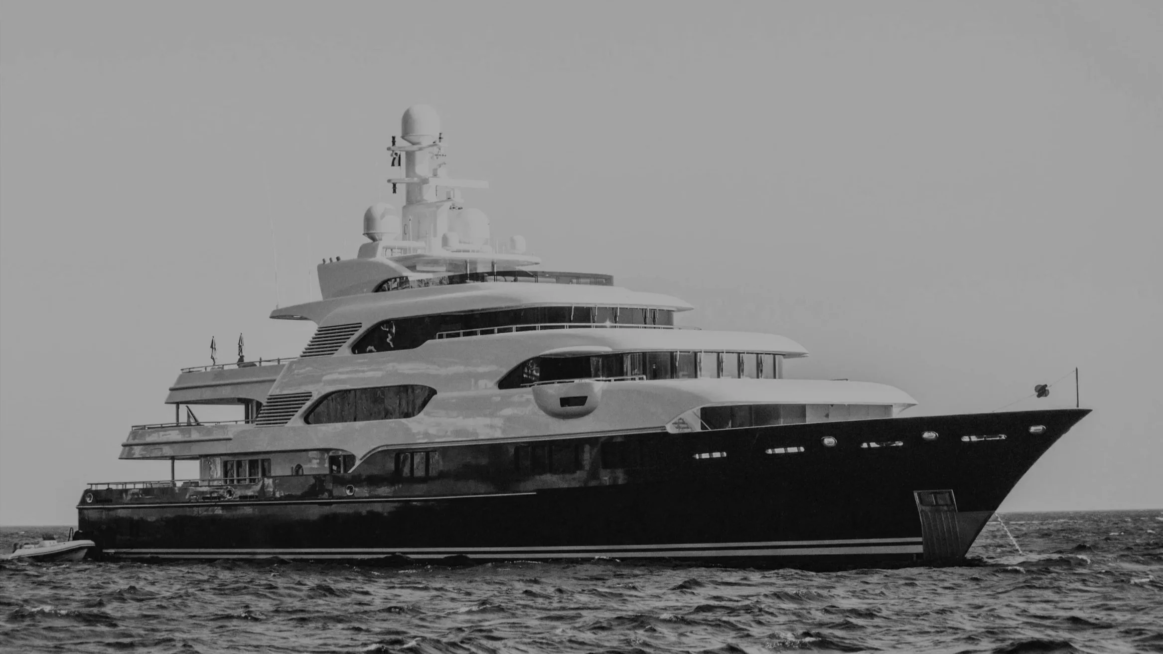 A large luxury yacht sailing on the ocean, seen from the side in black and white.
