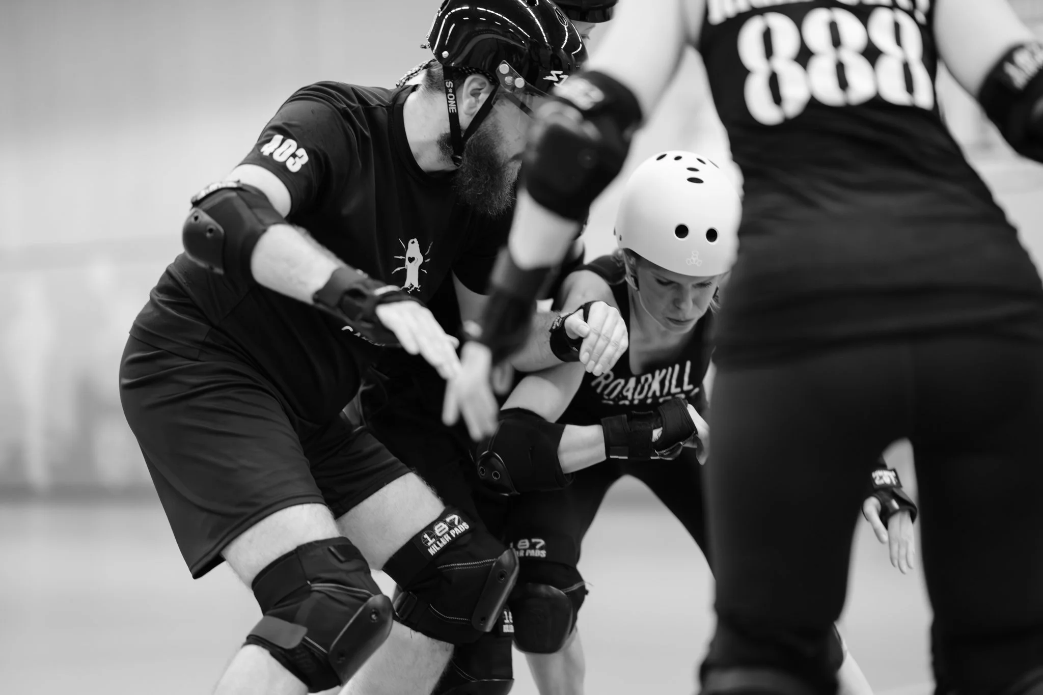Drie inline skaters bij elkaar tijdens een practicum, met beschermende helm en uitrusting.