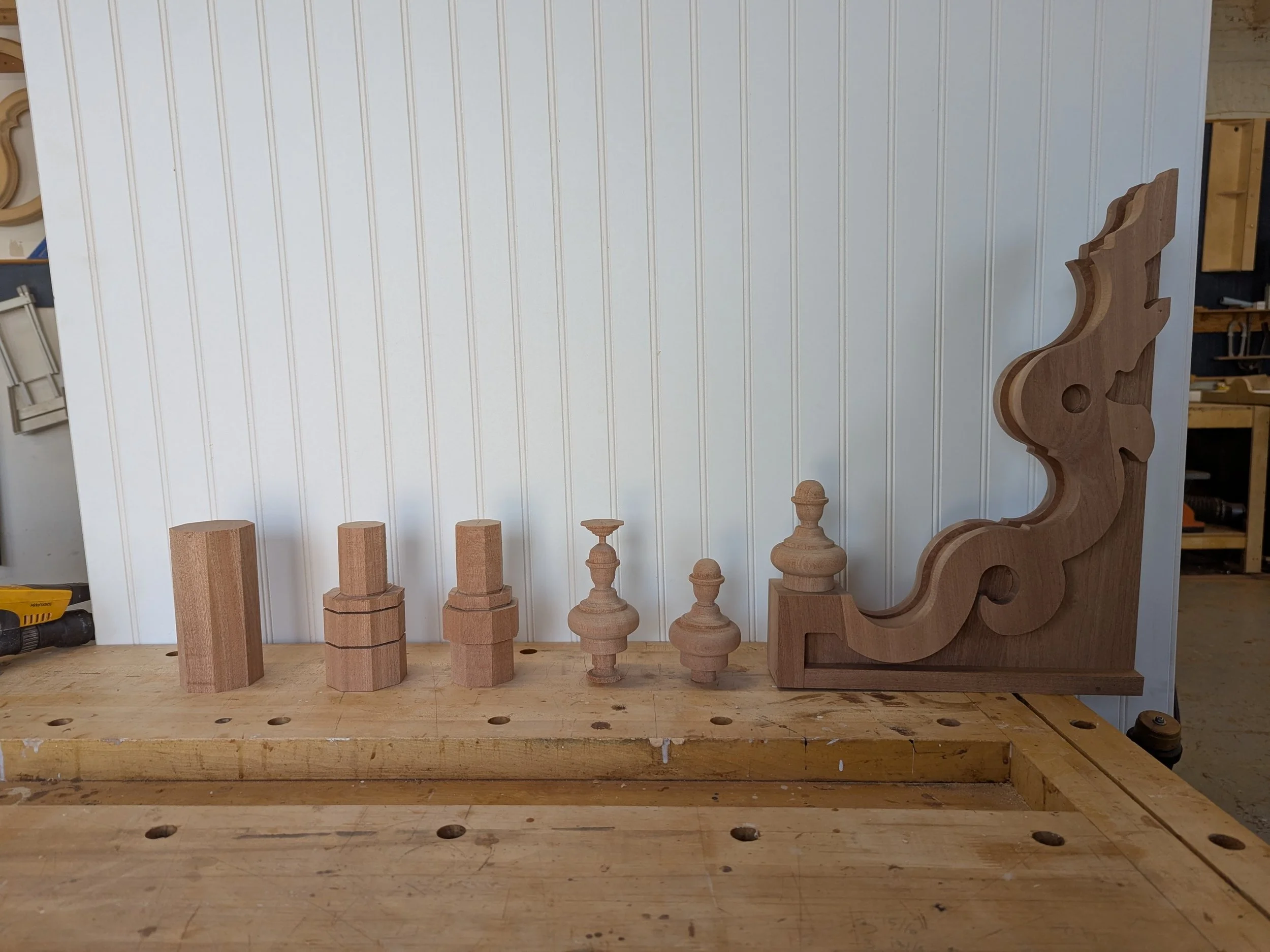 Various unfinished wooden chess pieces and a decorative tree-shaped board on a workbench.