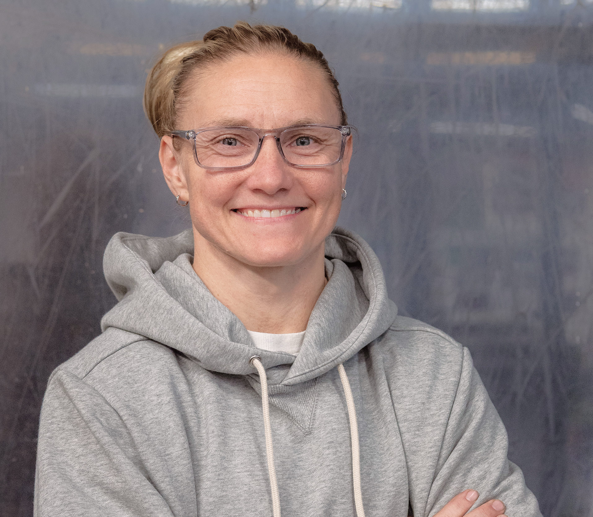 A care professional smiling at the camera in a casual, welcoming setting.