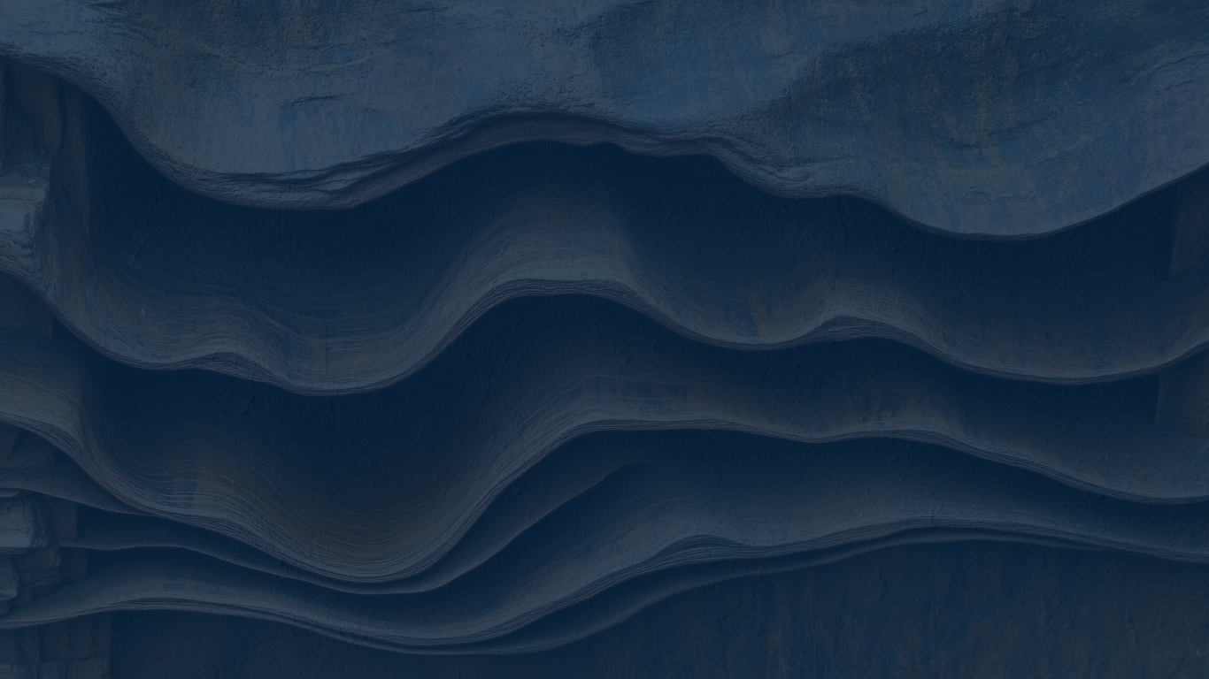 Aerial view of layered, wave-like rock formations in shades of blue.