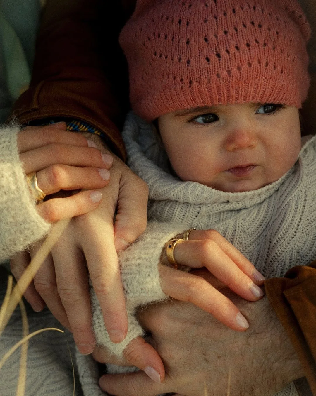 un bébé dans les bras de ses parents 