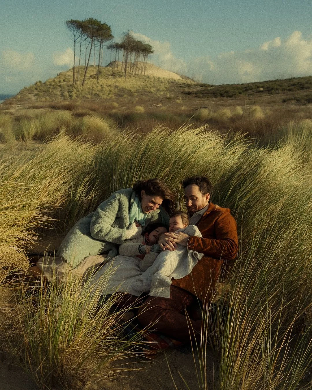 une famille dans les hautes herbes qui se fait un calin