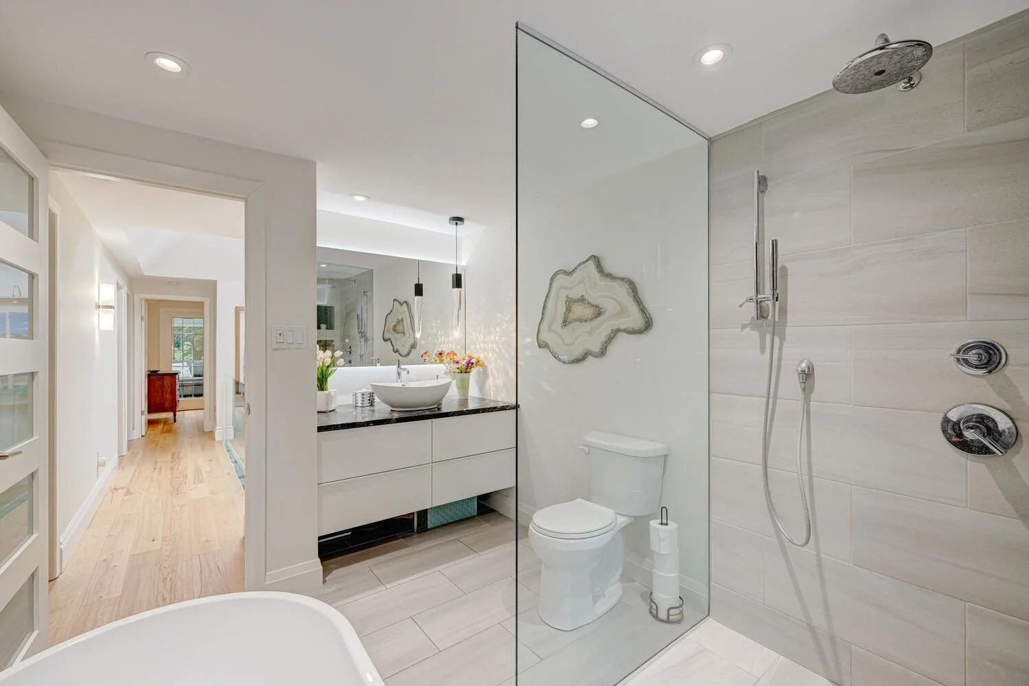 After picture of completed bathroom with sink and glass shower, showcasing modern finishes and fixtures by Burcon Construction.