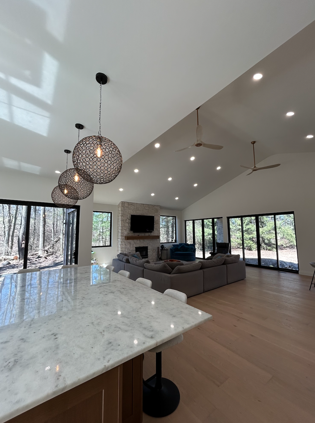 Modern kitchen island and living room in newly built home project by Burcon Construction in Mount Brydges, showcasing craftsmanship and contemporary design