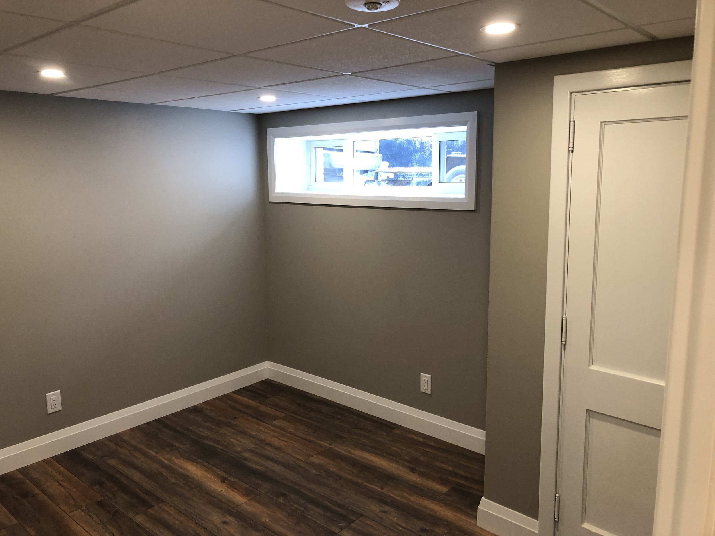 Completed basement bedroom in London by Burcon Construction, offering comfort and privacy for tenants.