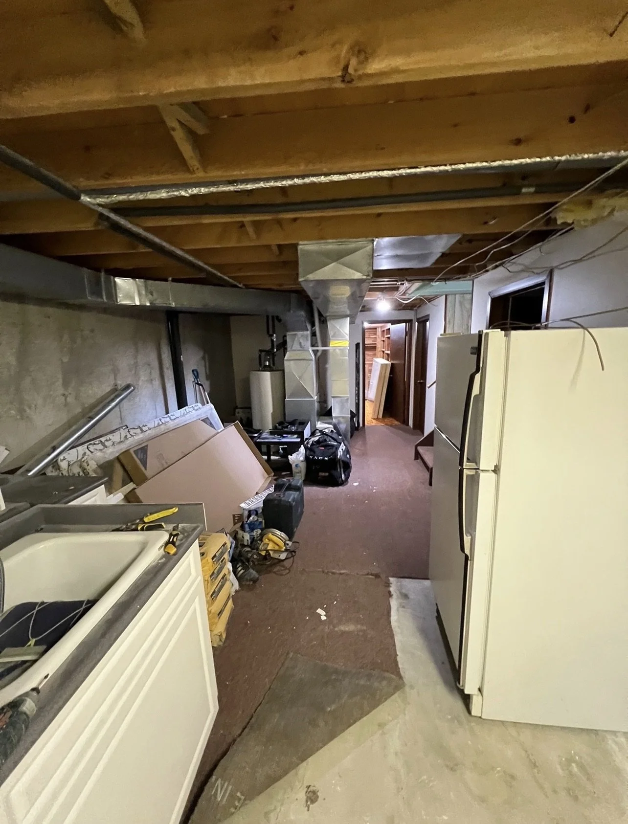 Before picture of unfinished basement in West London prior to renovation by Burcon Construction, highlighting the area before transformation.