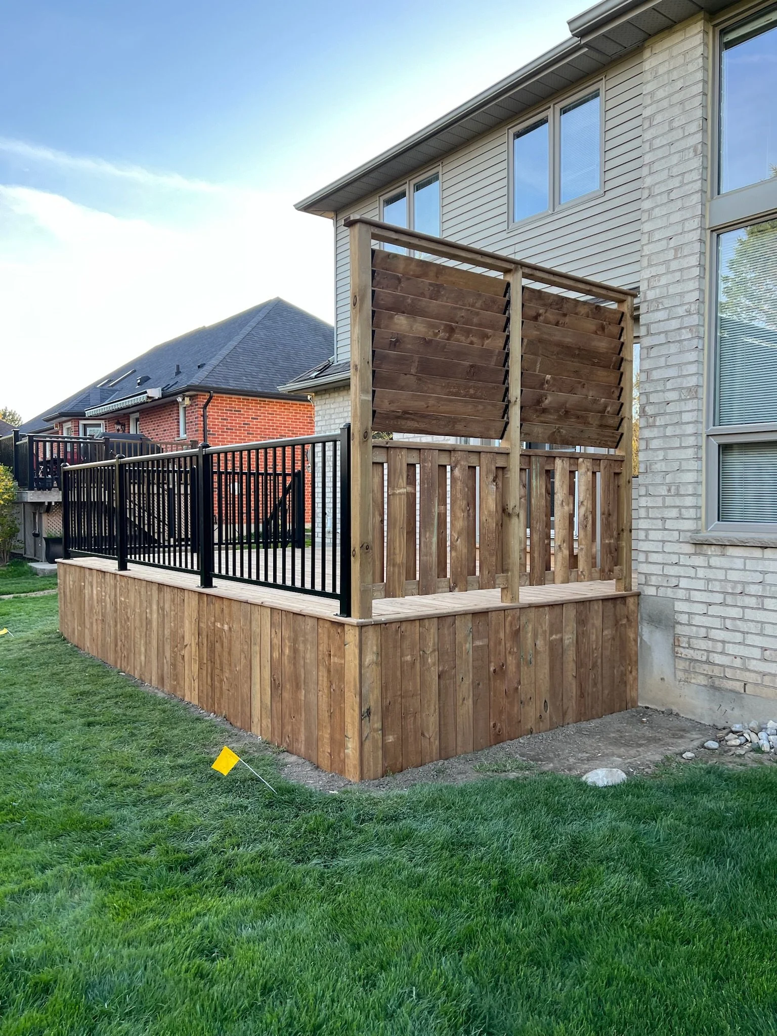 Completed deck in Kilworth by Burcon Construction, featuring wooden privacy shutters for added privacy and aesthetics.