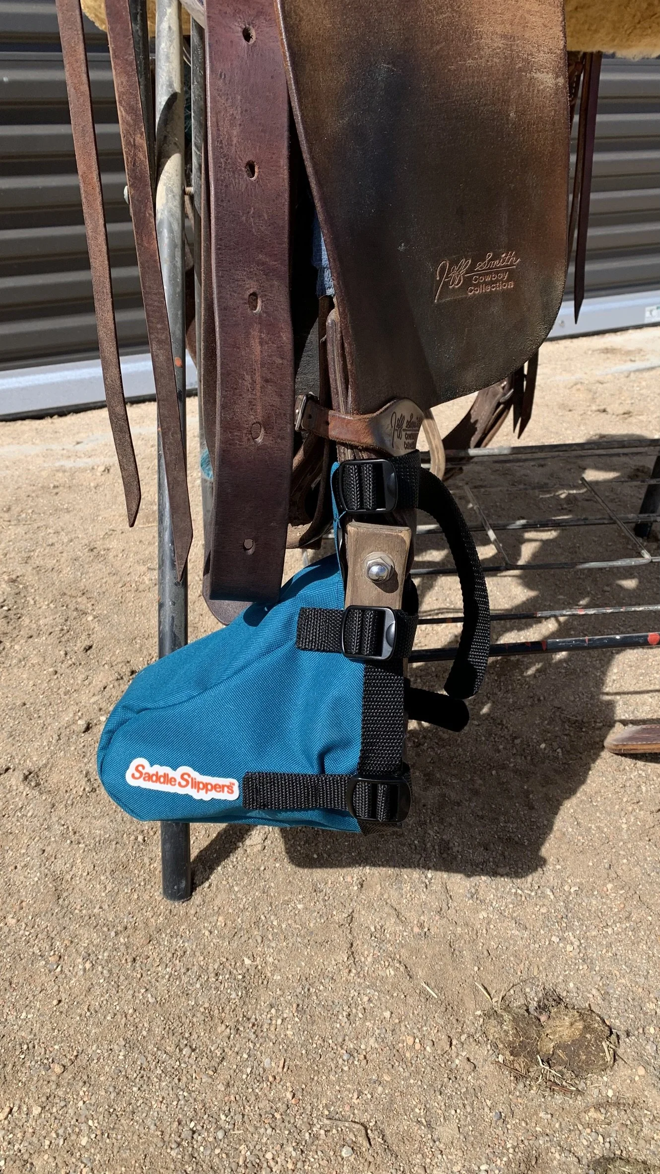 A turquoise Saddle Slipper attached to a stirrup and saddle sitting on a stand.