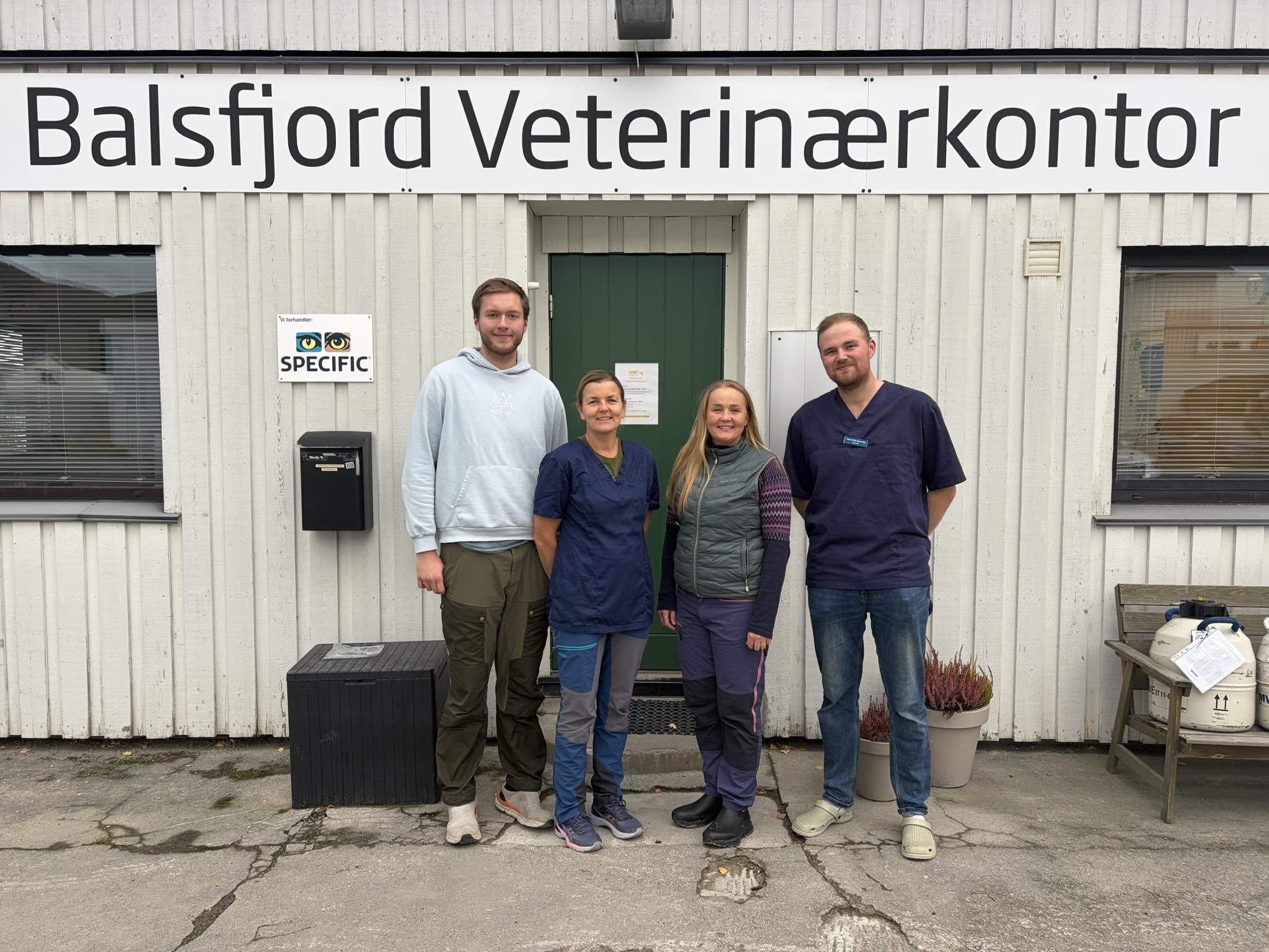 Fire personer står utenfor veterinærkontoret i Balsfjord, klare for arbeid.