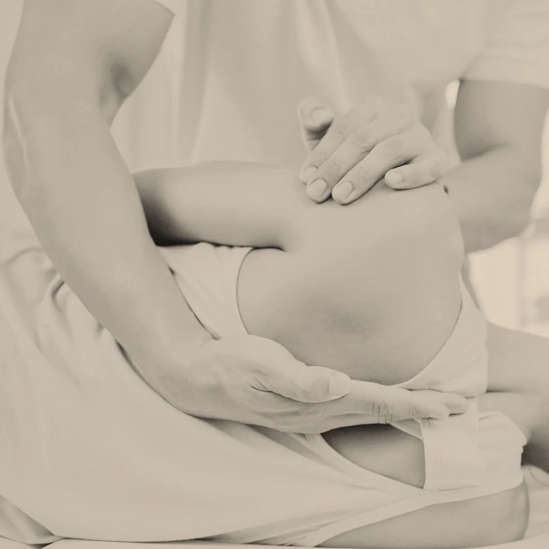 Person practicing hands-on physical therapy, adjusting a patient's shoulder.