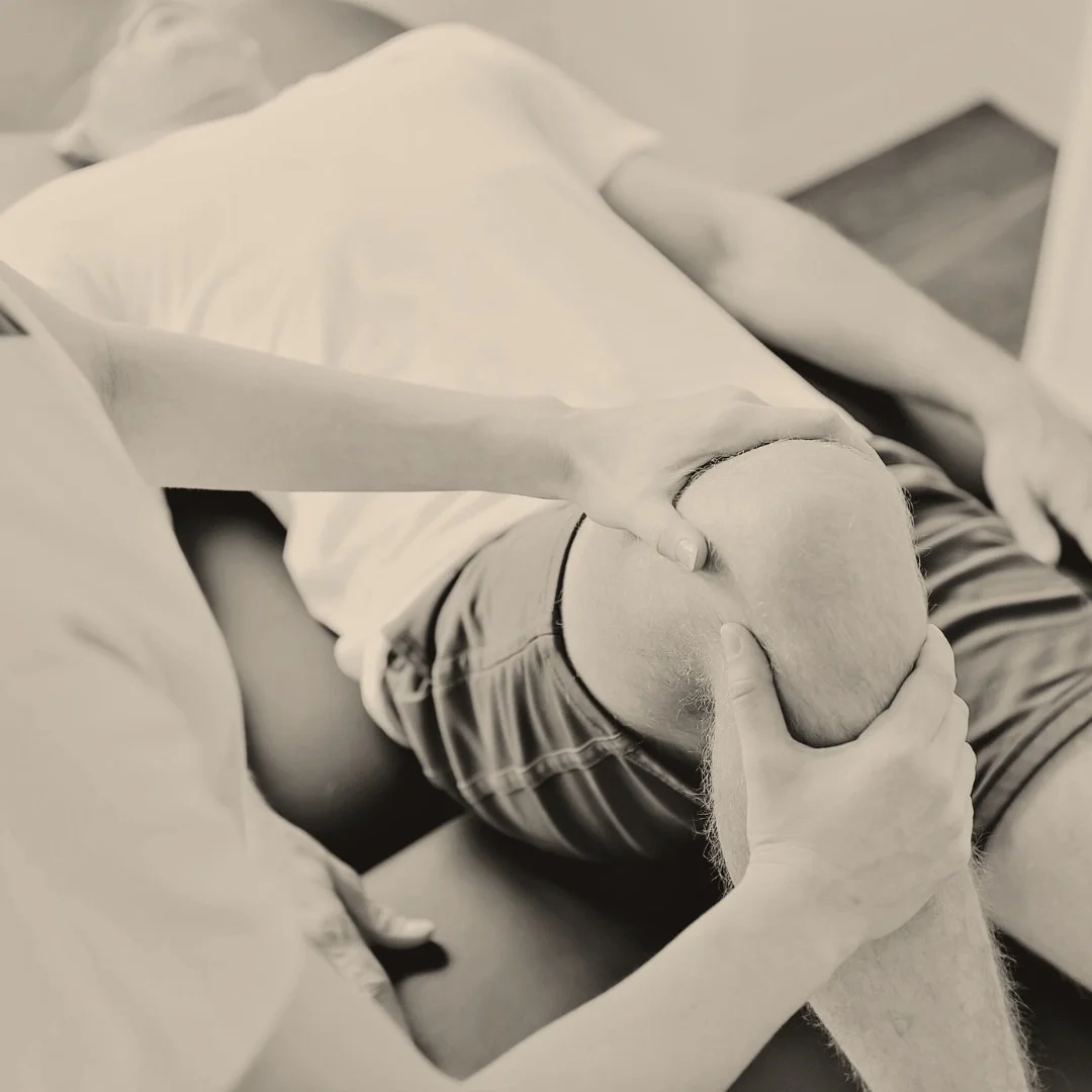 Person receiving knee examination or physical therapy from a therapist.