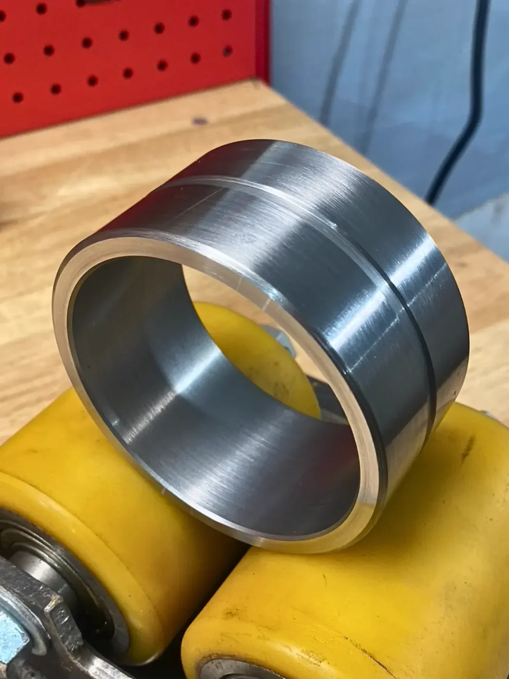 Custom machined 4140 steel excavator quick attach bushing manufactured for wear resistance and proper equipment fitment