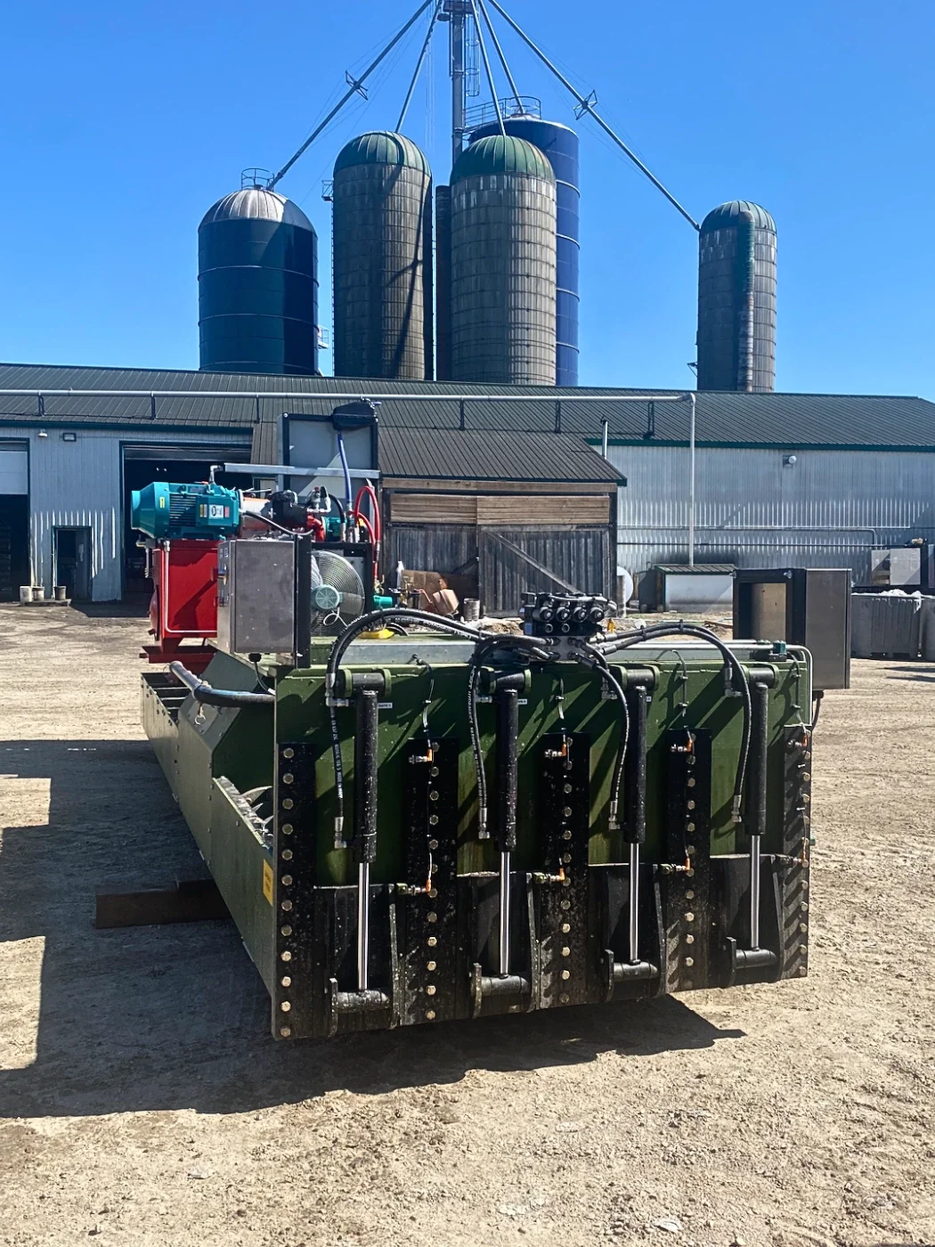 Front view of custom-built industrial garbage press designed to separate liquid from wet cardboard and packaging waste for recycling and waste processing applications.