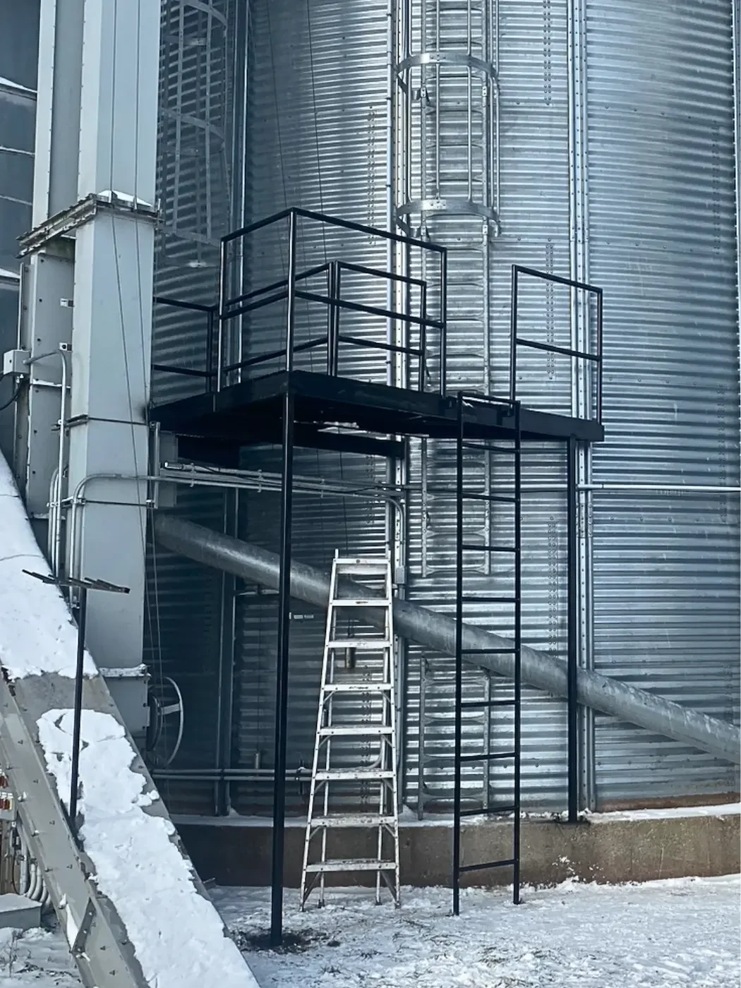 Custom steel platform and ladder installed on a grain elevator for safe maintenance access.