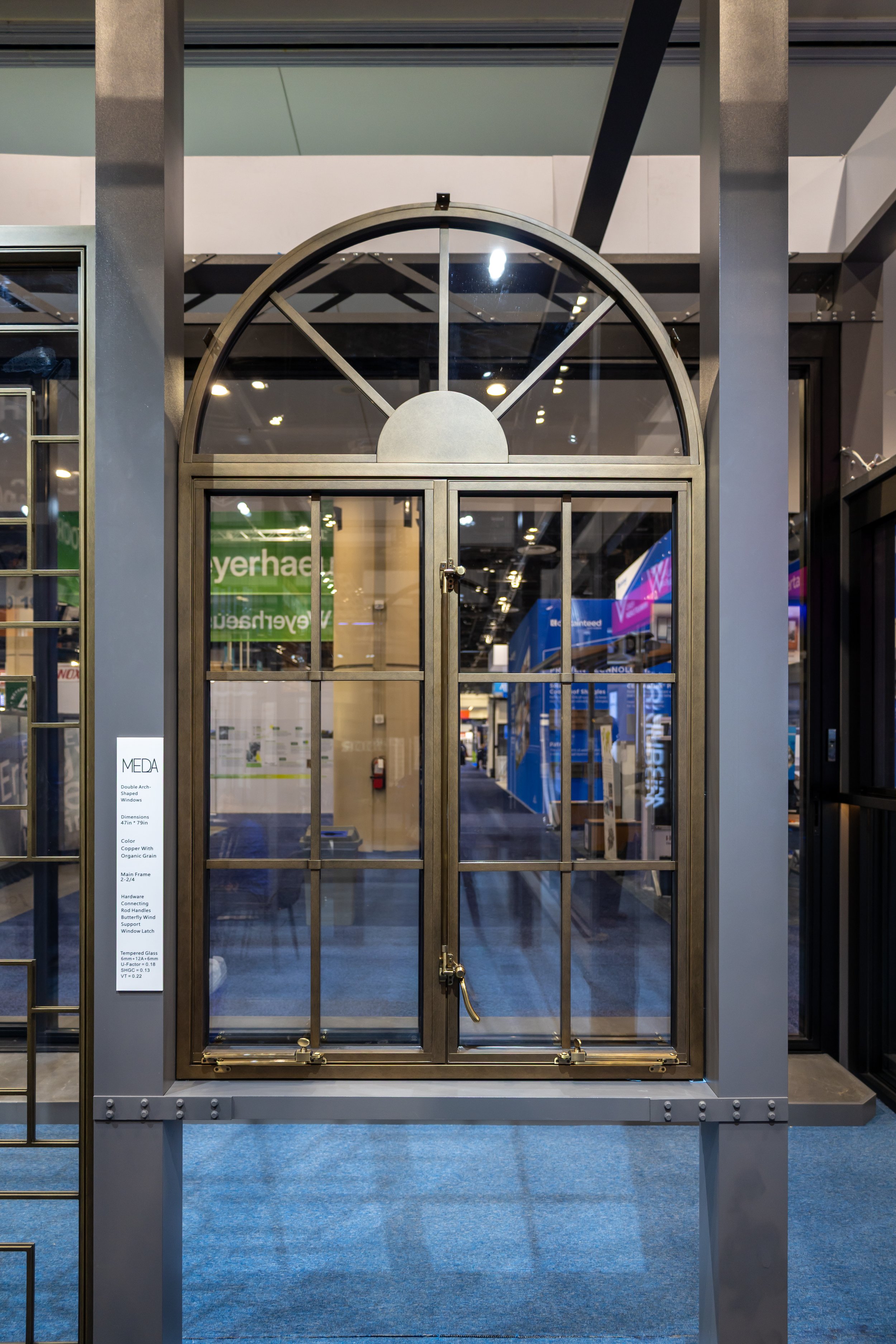 Display of a metal arched window with multiple glass panes at a store or exhibition.