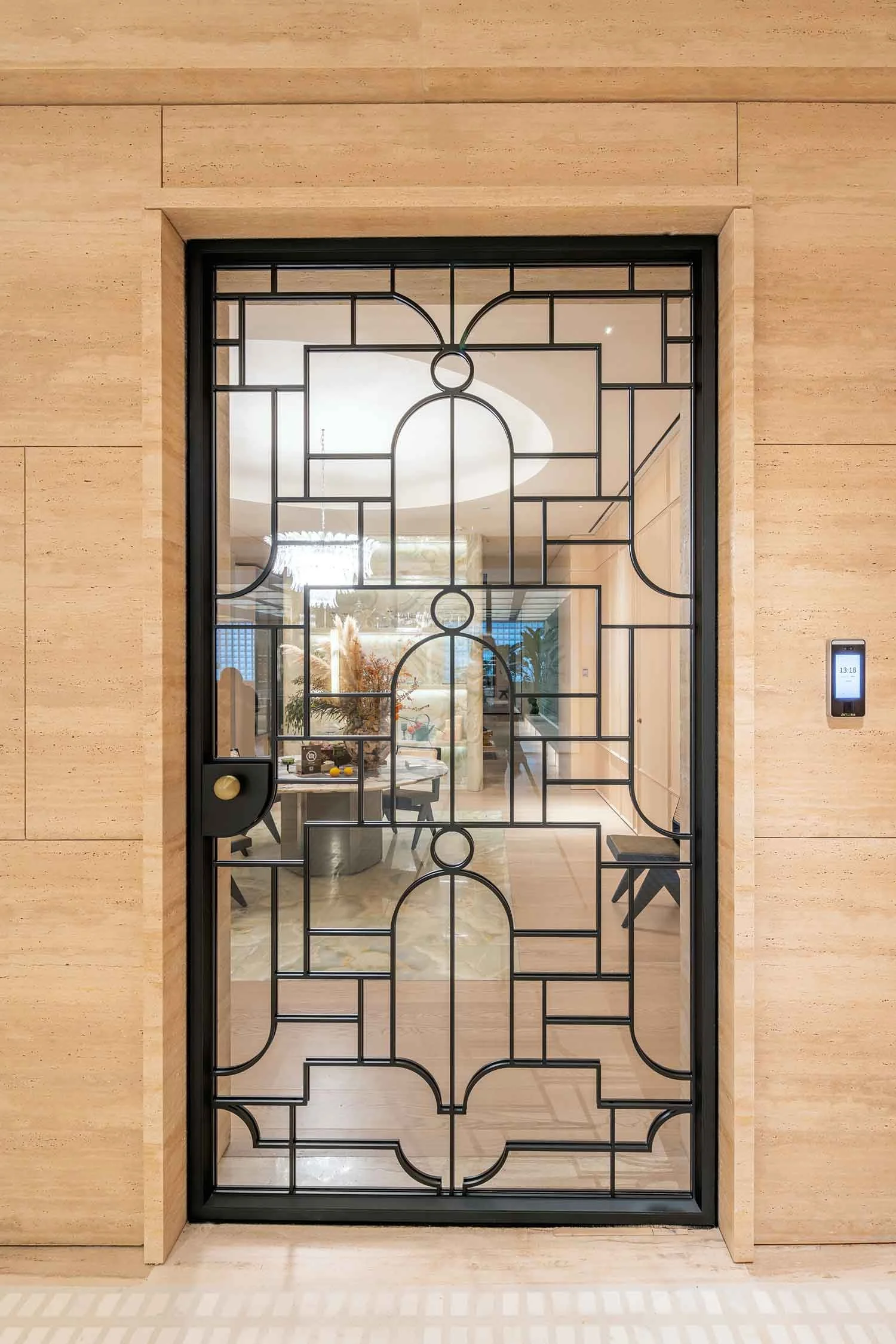 Decorative glass door with black geometric patterns leading to a dining and living area inside a modern home.