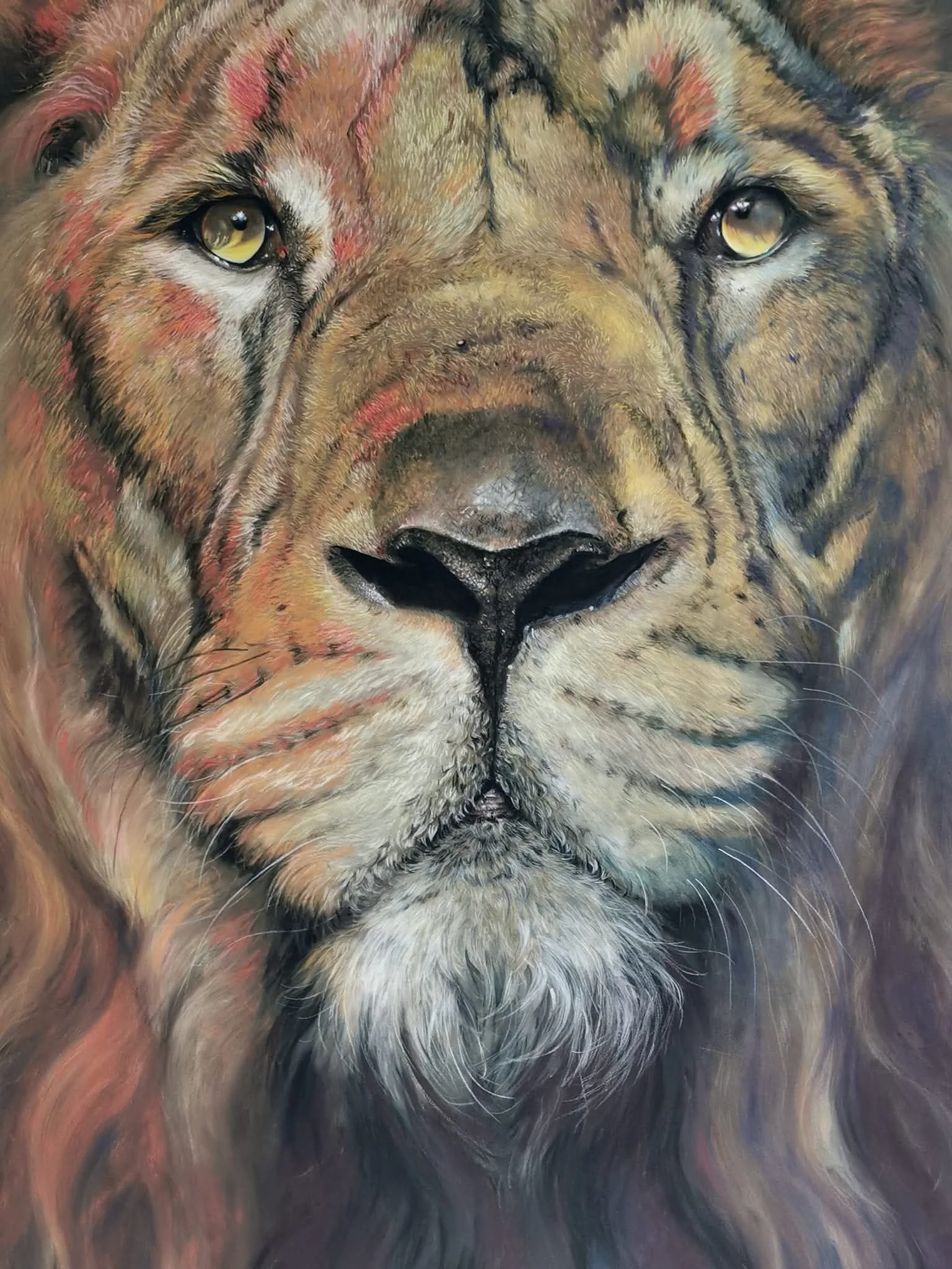 Close-up of a detailed painting of a lion's face with golden eyes, black nose, and a mixture of brown, tan, black, and white fur.