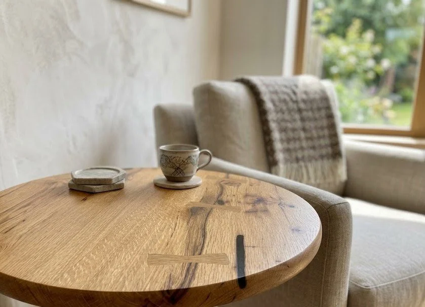 Bowtie inlays and black epoxy fills on a rustic white oak round table top. 