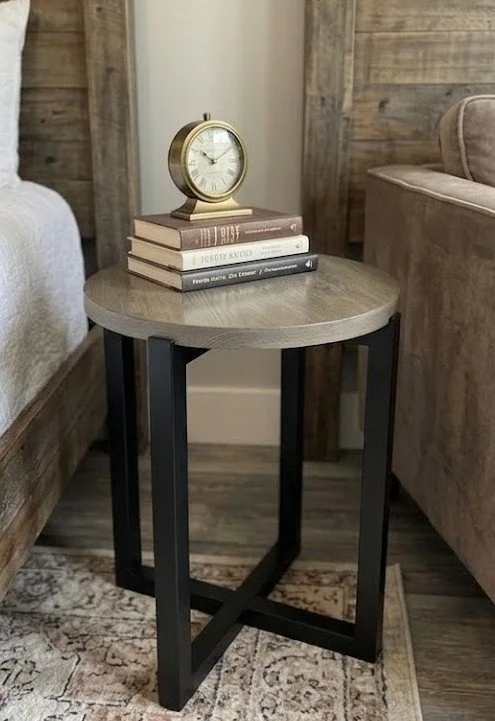 Modern round oak side table with black painted cross leg base. 