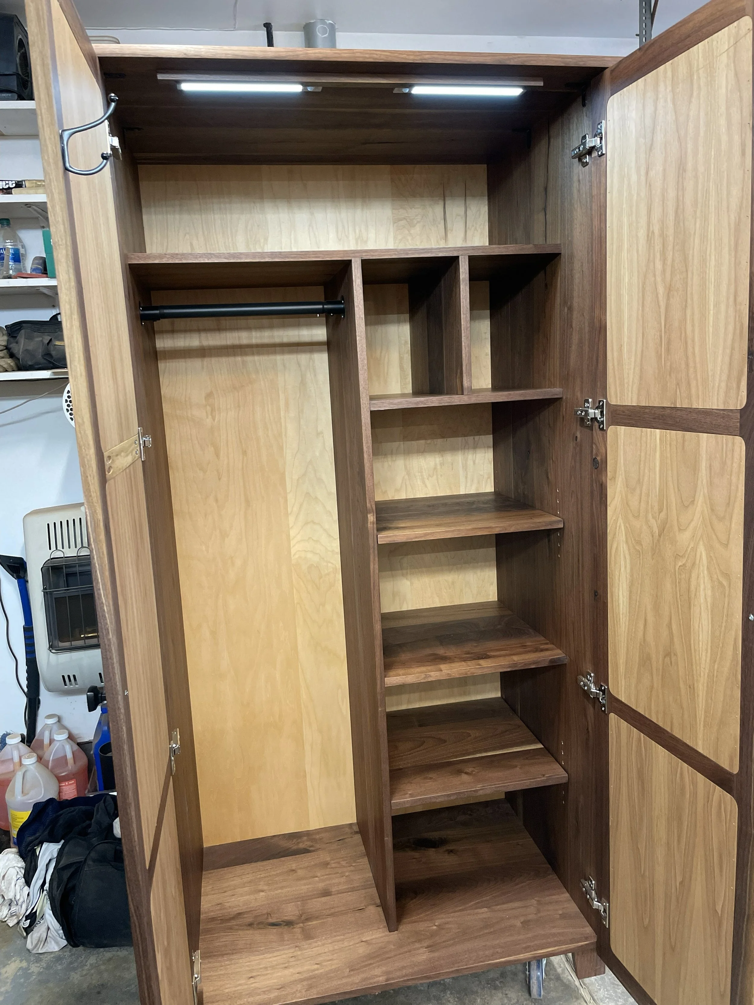 Custom solid walnut wardrobe with internal shelving and interior lights. 