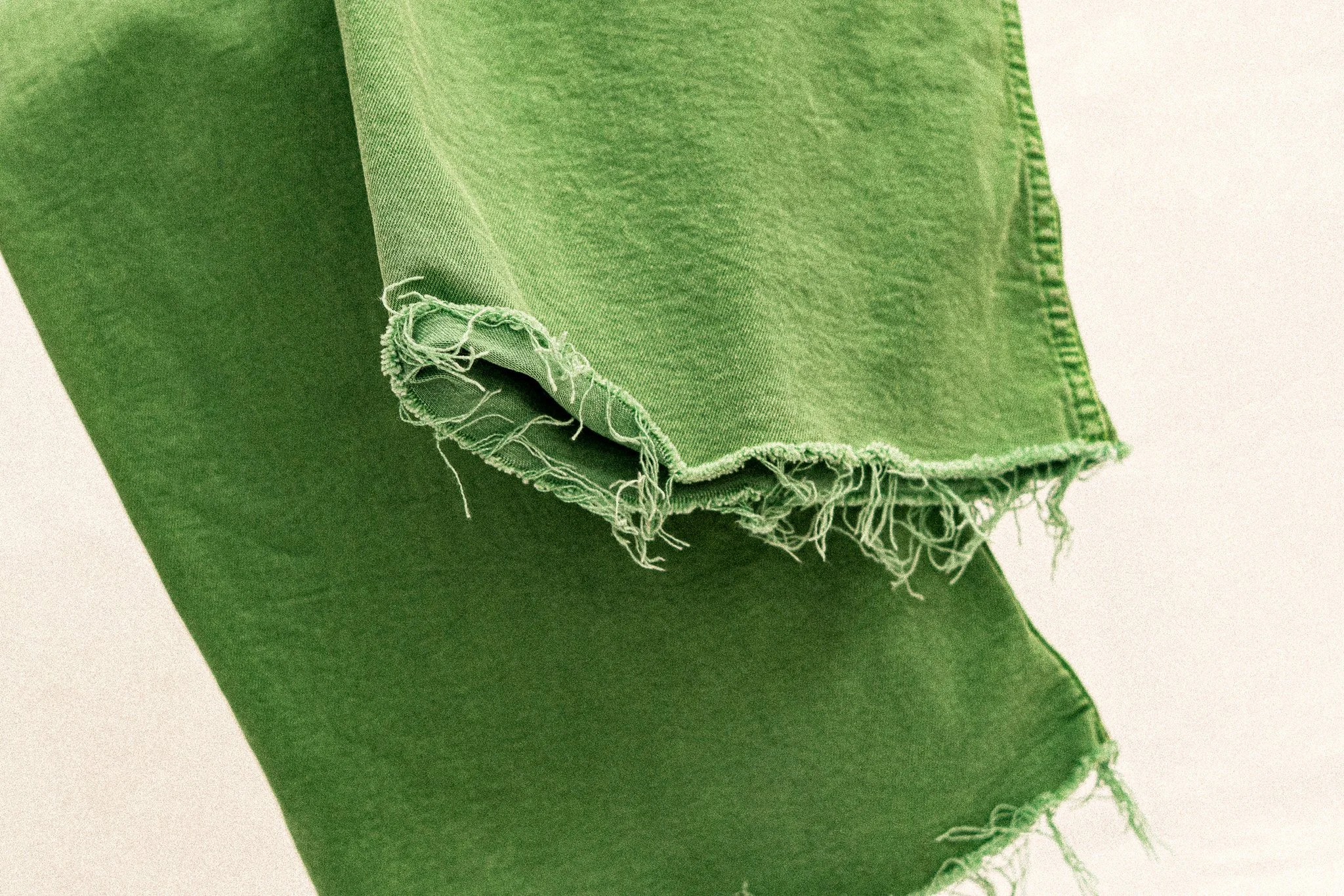 Un tissu en jean vert avec un déchirure aux extrémités.