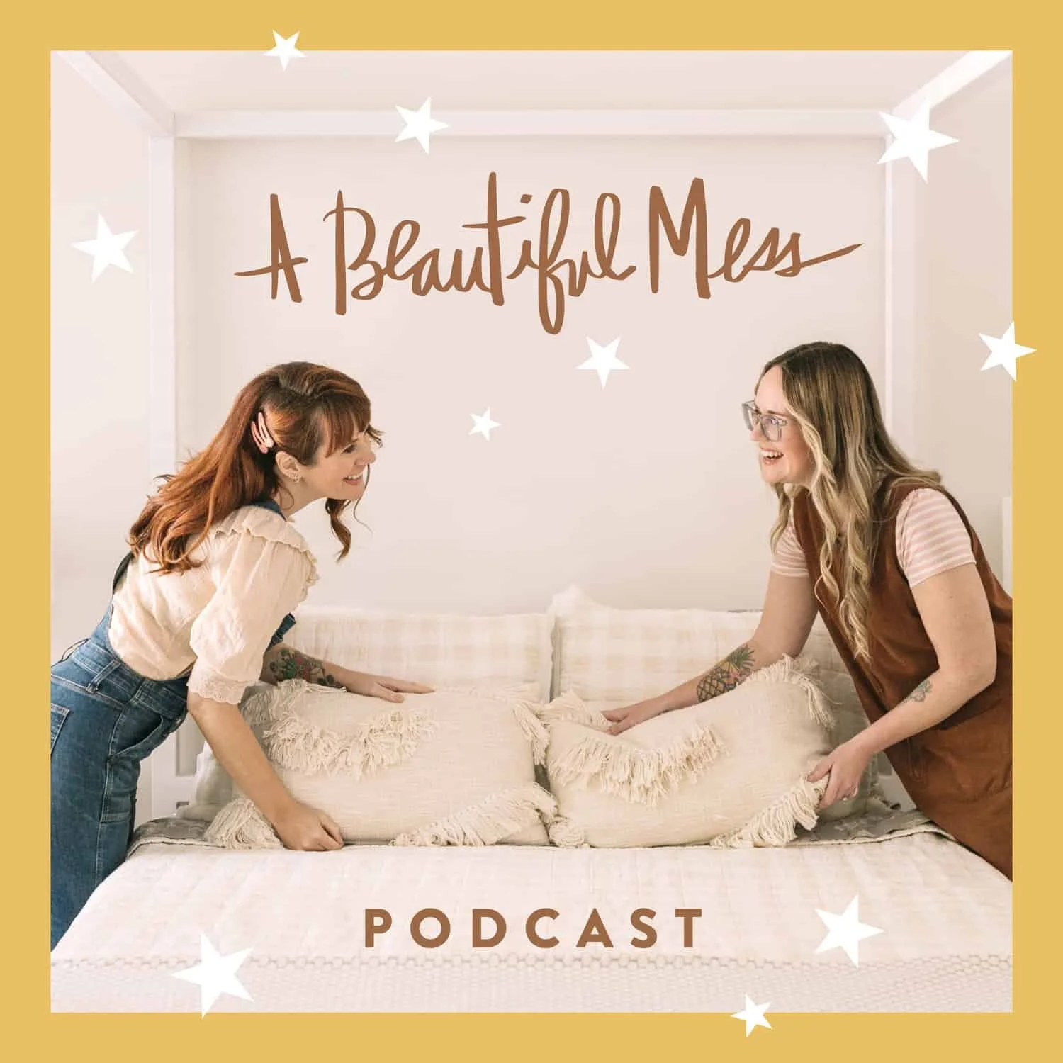 Two women smiling and leaning on a bed with pillows, facing each other in a cozy room with a sign that says "A Beautiful Mess" and the word "PODCAST" underneath, surrounded by star effects.