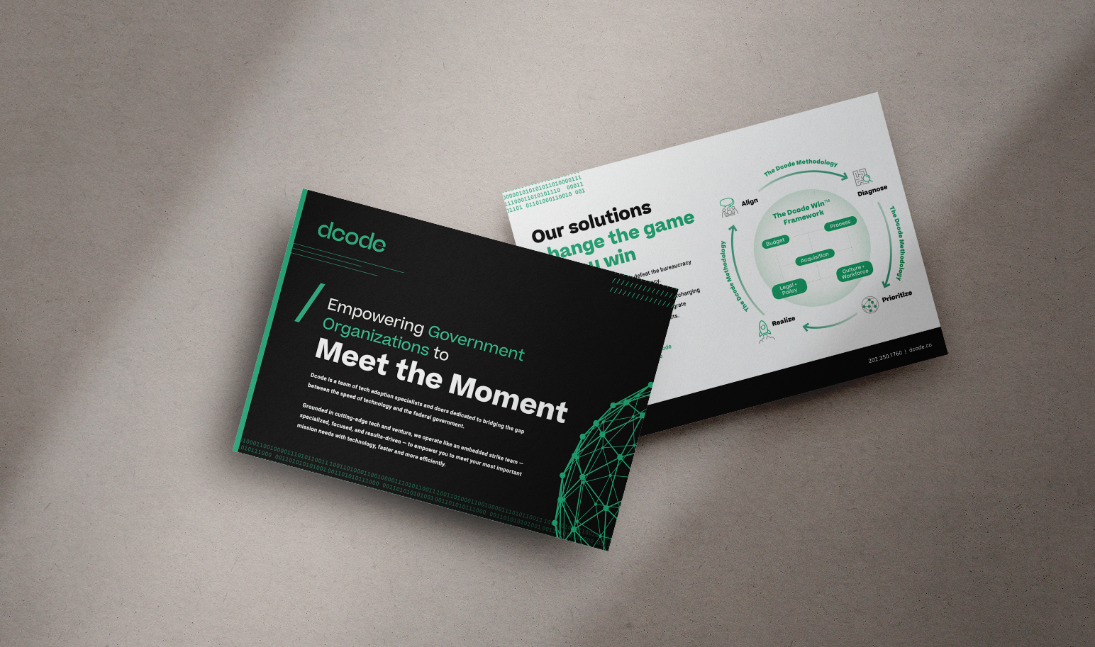Two printed brochures on a gray surface, one with a black background and teal and white text, the other with a white background and green and black text, related to government technology solutions.