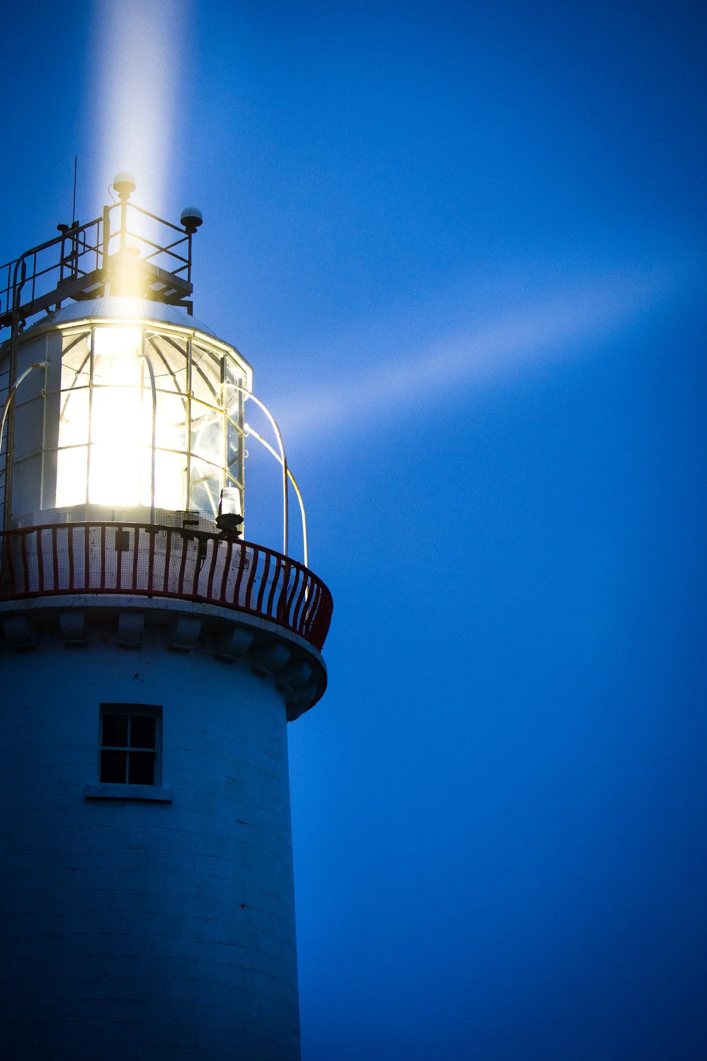 lighthouse at blue hour shining a safe path