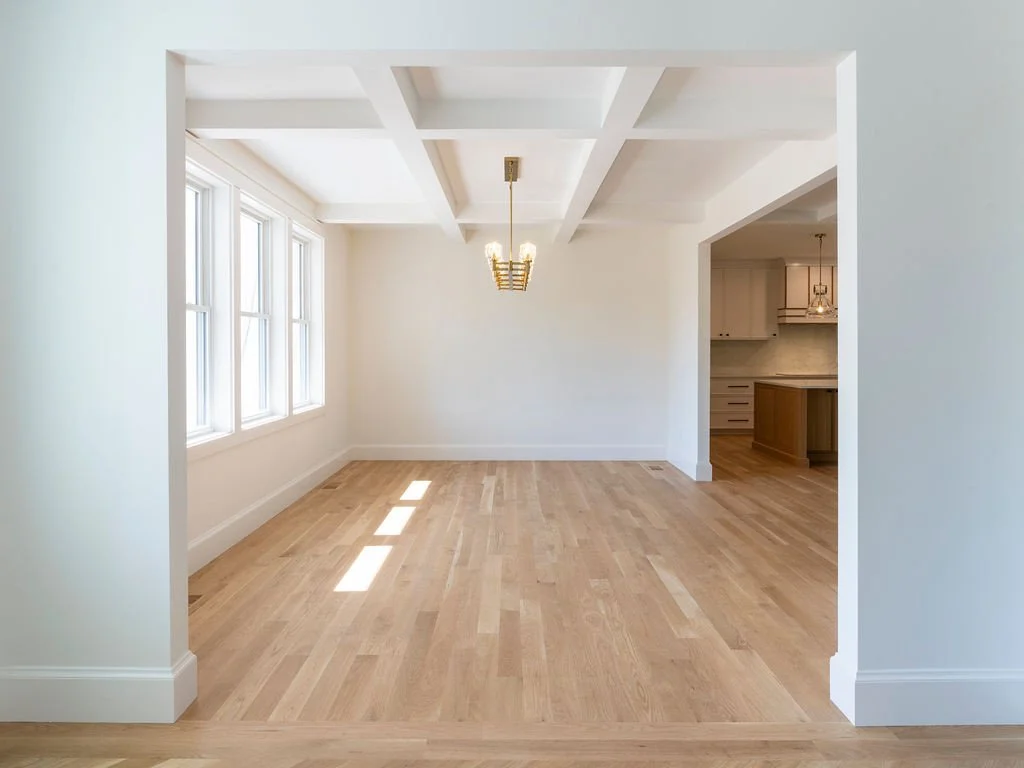 A dining space shaped by light and detail. Coffered ceilings add depth and structure overhead, while natural light pours in to keep the room feeling open and inviting. Seamlessly connected to the kitchen, it&rsquo;s designed for both everyday living 
